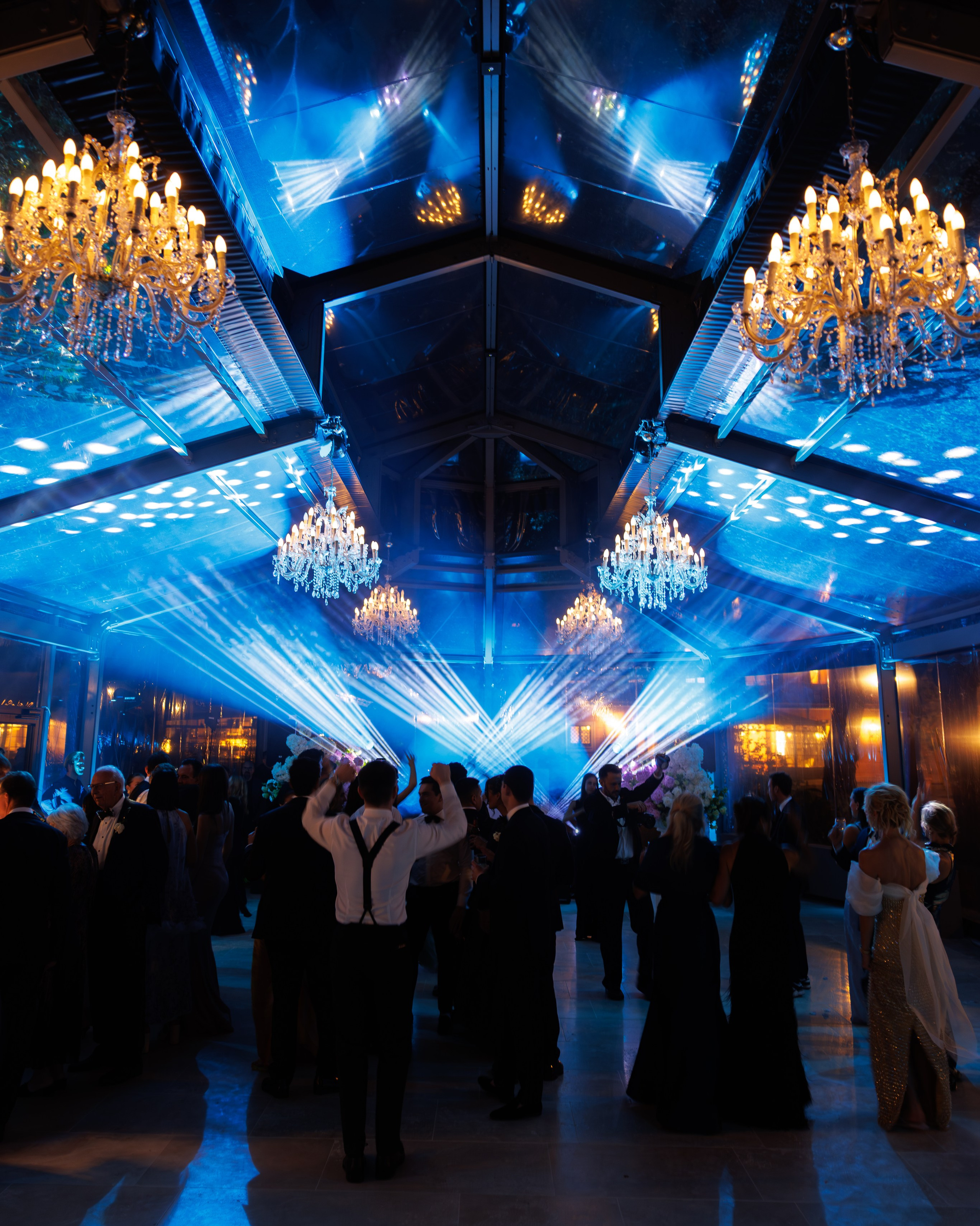 Wedding reception dance floor with dramatic blue lighting and guests celebrating — wedding photographer Toronto