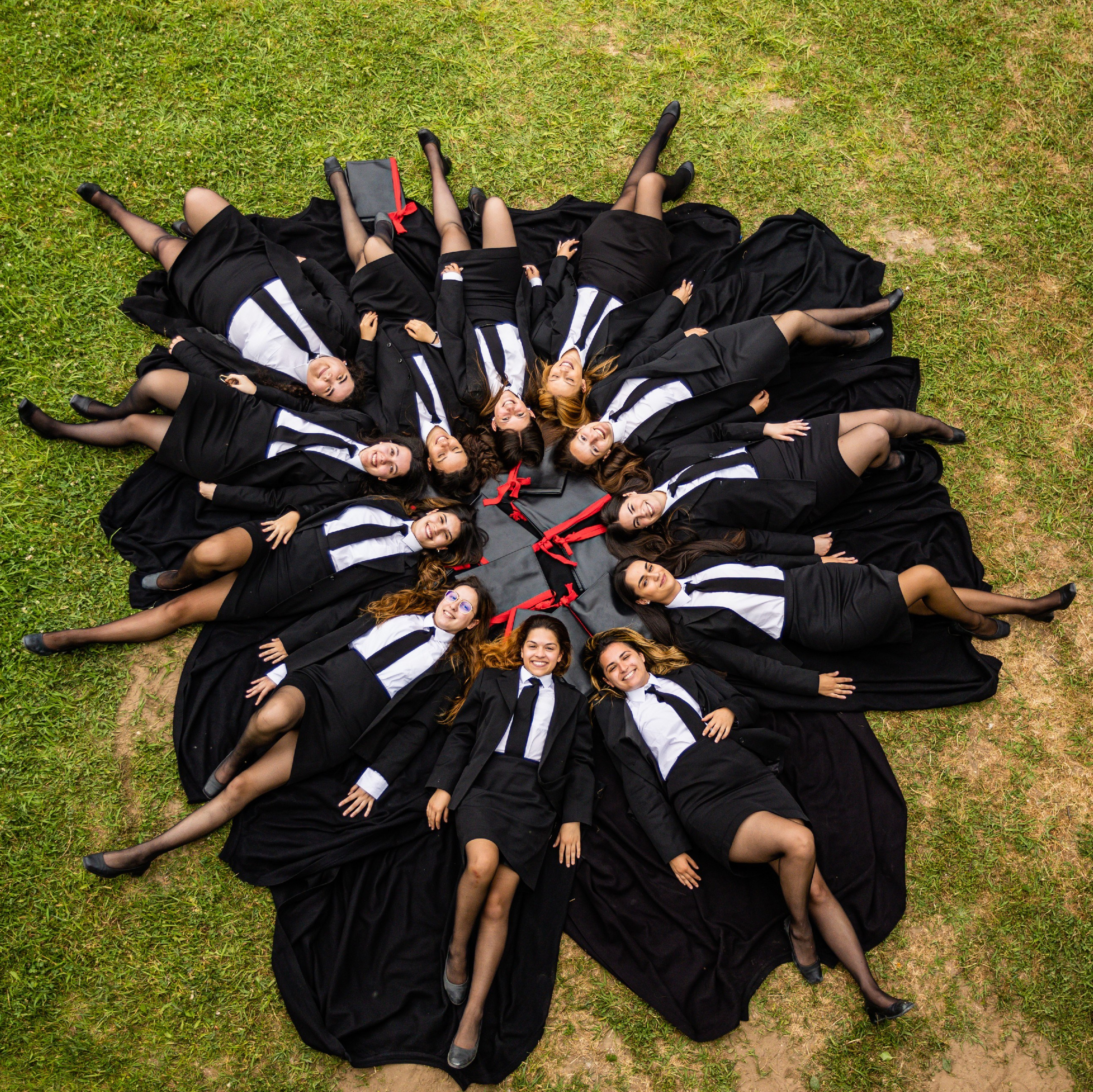 Grupo de estudantes com traje académico fotografado no exterior