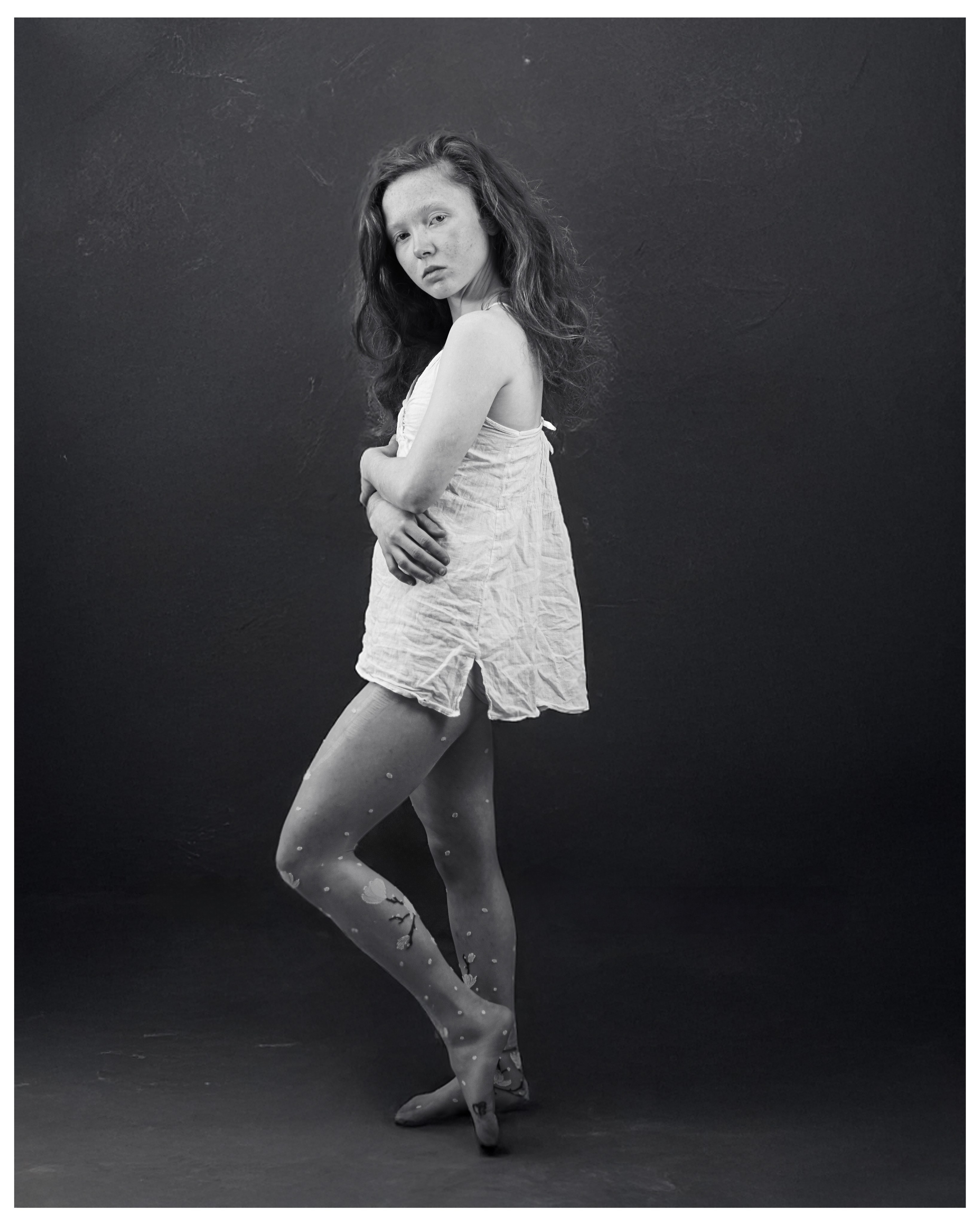 Black and white portrait of a standing woman in studio light — creative photography by AMELPOMENEM in Ireland.