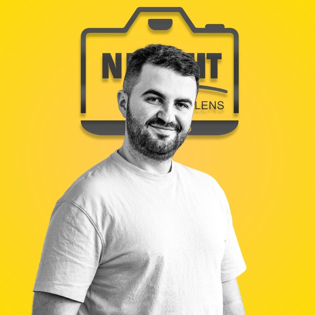 Portret profesional al unui bărbat pe fundal galben cu logo, expresie zâmbitoare