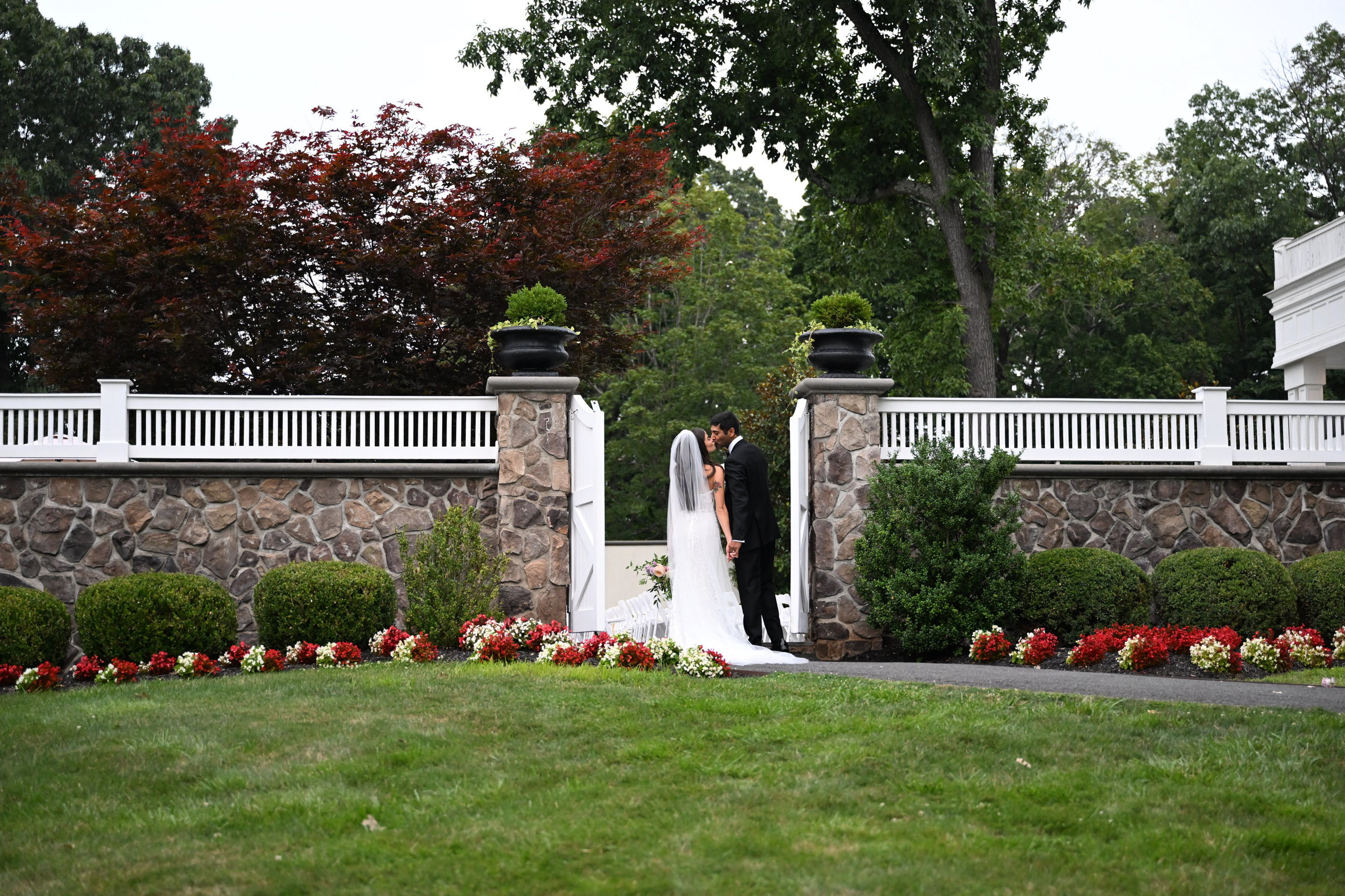 a bride and groom standing in front of a stone wall