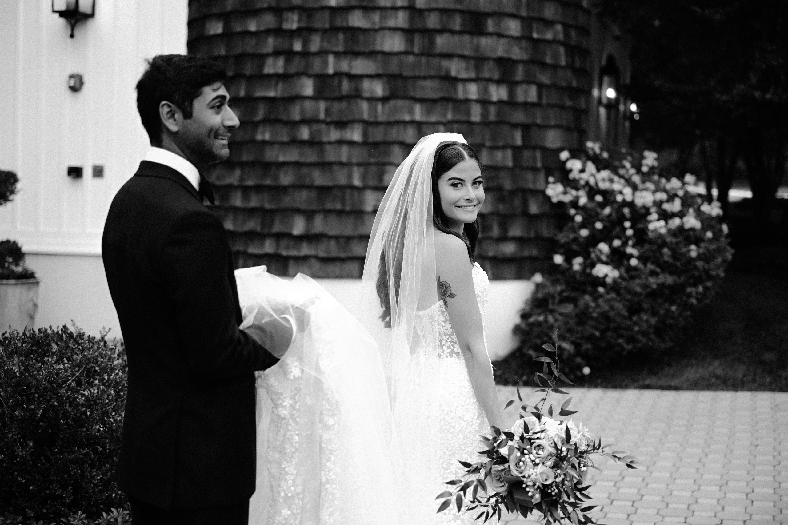 a bride and groom standing outside of a house