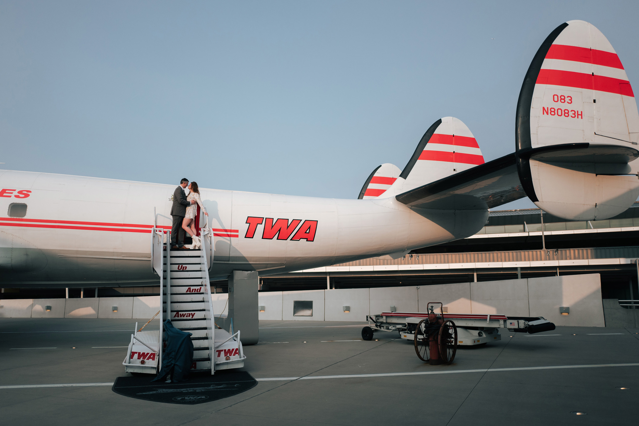 a man standing on a ladder next to a plane
