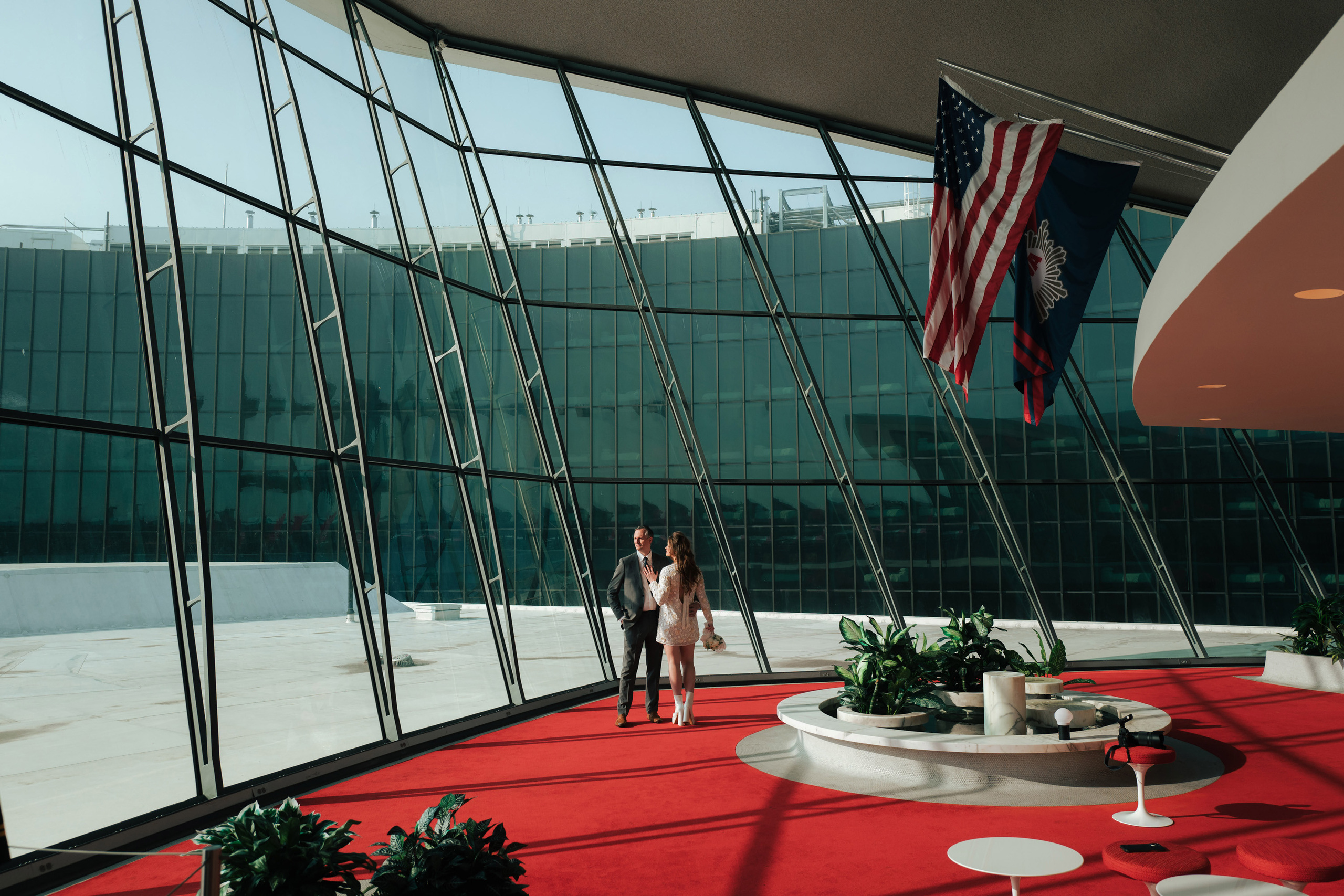 a couple standing in a large room with a flag