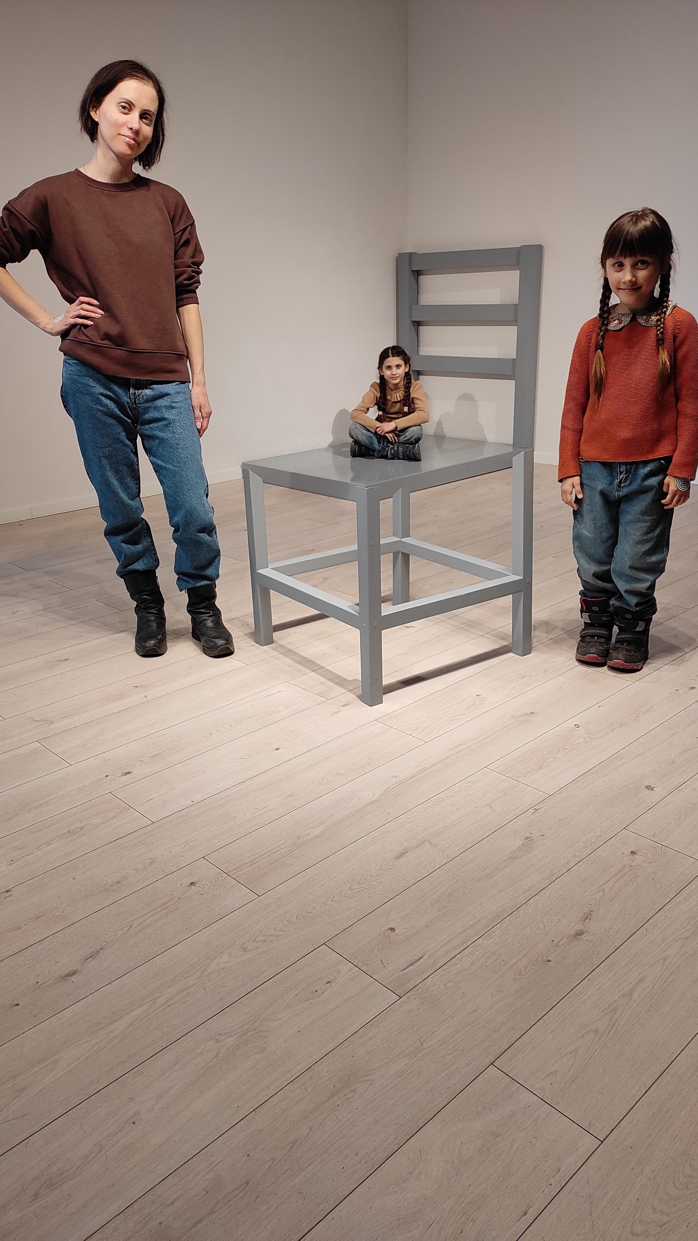 Фотографія - ілюзія, що стілець великий, а людина на стільці маленька