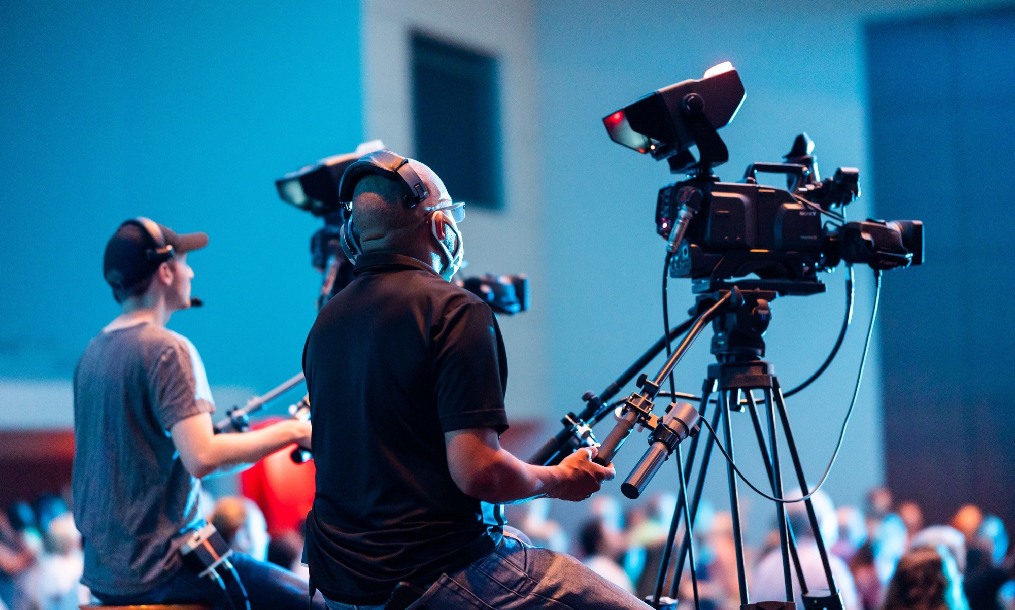 Two camera operators filming a corporate event with a professional multi-camera setup