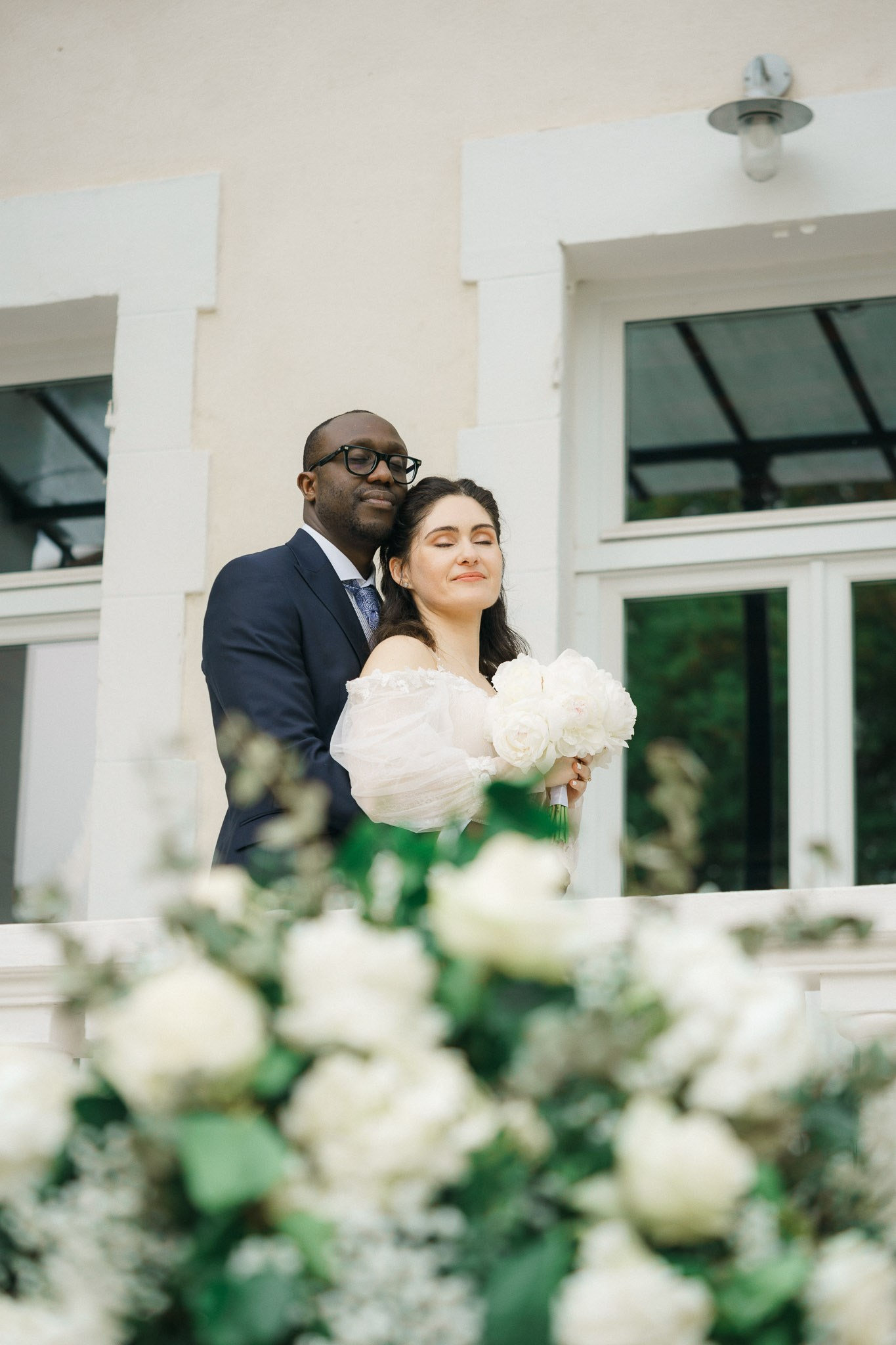 photo of a bride and groom standing on a checkered floor balcony,