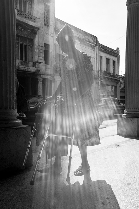 Woman walks inside the colonnade on Galeano street, Centro Habana district, Havana, Cuba. 2016