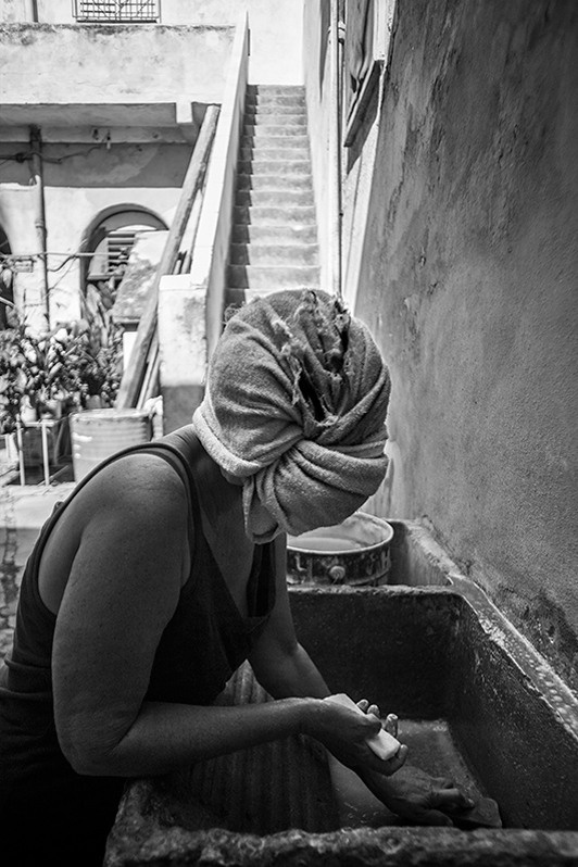 My neighbour finishes washing her hair outside her house, Reina street, Centro Habana district, Havana, Cuba. 2017