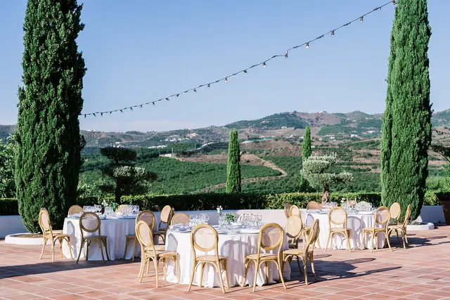 Wedding reception with round tables and brown chairs outside