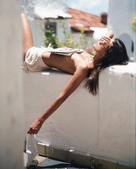 Model Lying on Balcony Ledge, Covering with Newspaper – Artistic and Bold Photography