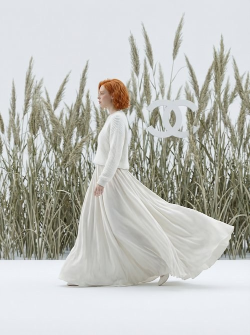 redhead fashion model in flowing white dress walking through tall grass minimalist fashion editorial photography