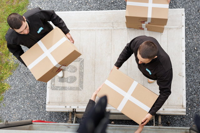 Vue du dessus de deux employés qui portent des cartons