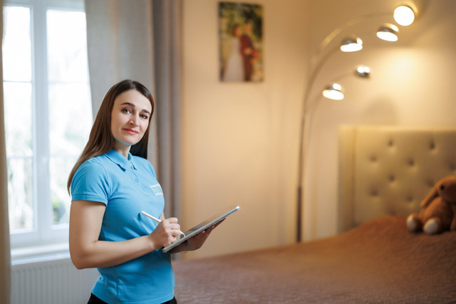 Une responsable de projet prend des notes sur sa tablette chez un client