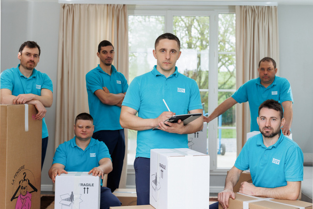 Portrait de groupe d'une équipe de sept personnes, cartons et tablette