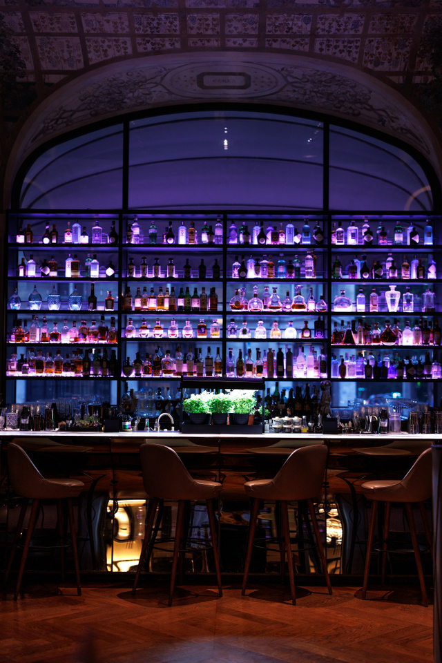 Grand bar éclairé le soir, bouteilles rétroéclairées