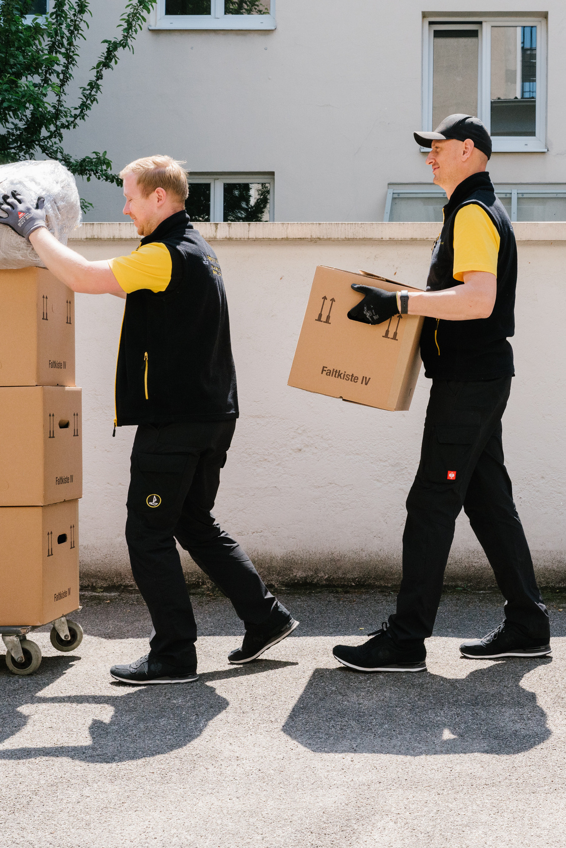Group of people in uniform transporting boxes