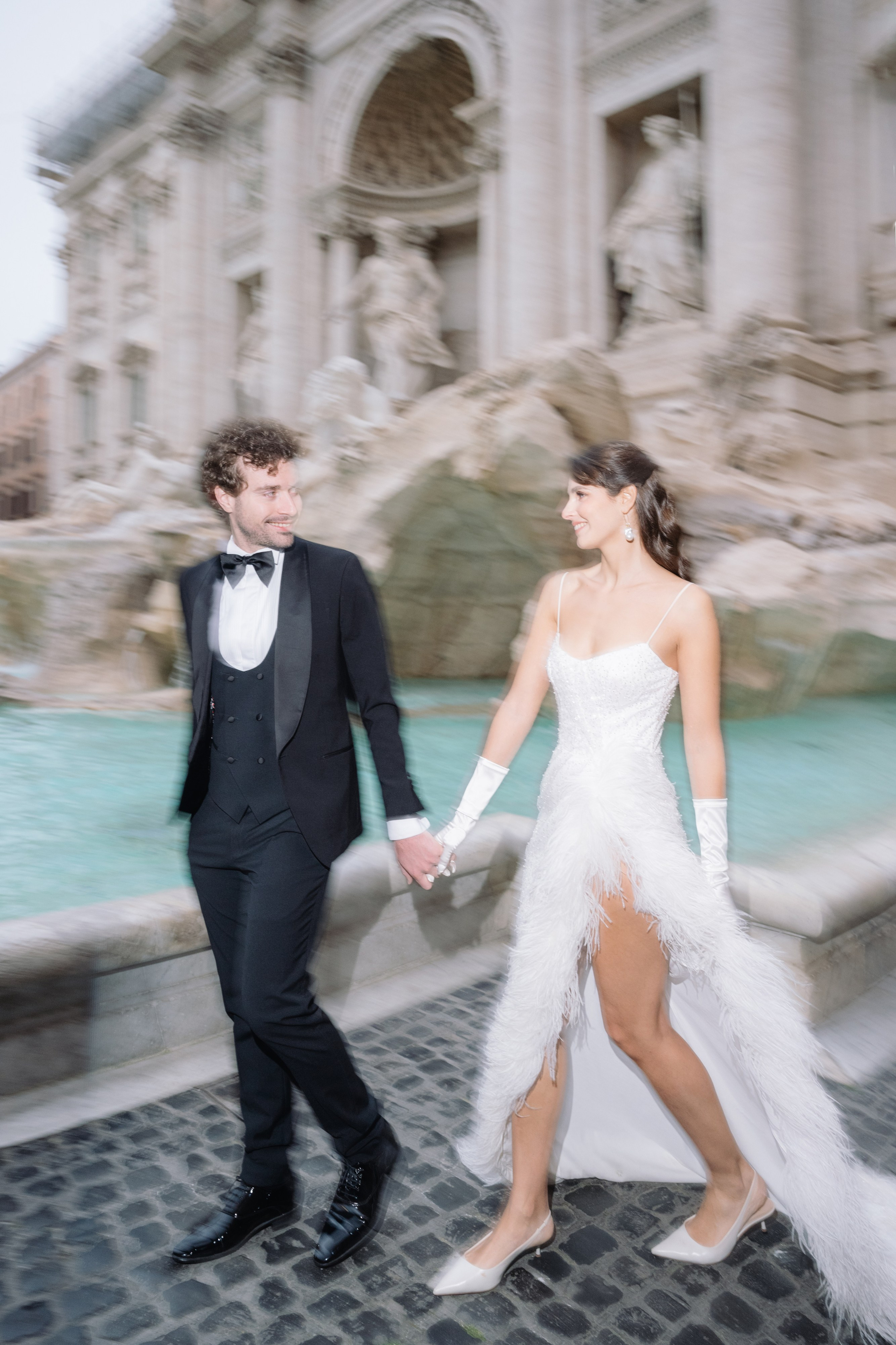 A cinematic elopement in Rome at sunrise, with quiet cobblestone streets, a vintage Vespa, and the Trevi Fountain in the rain