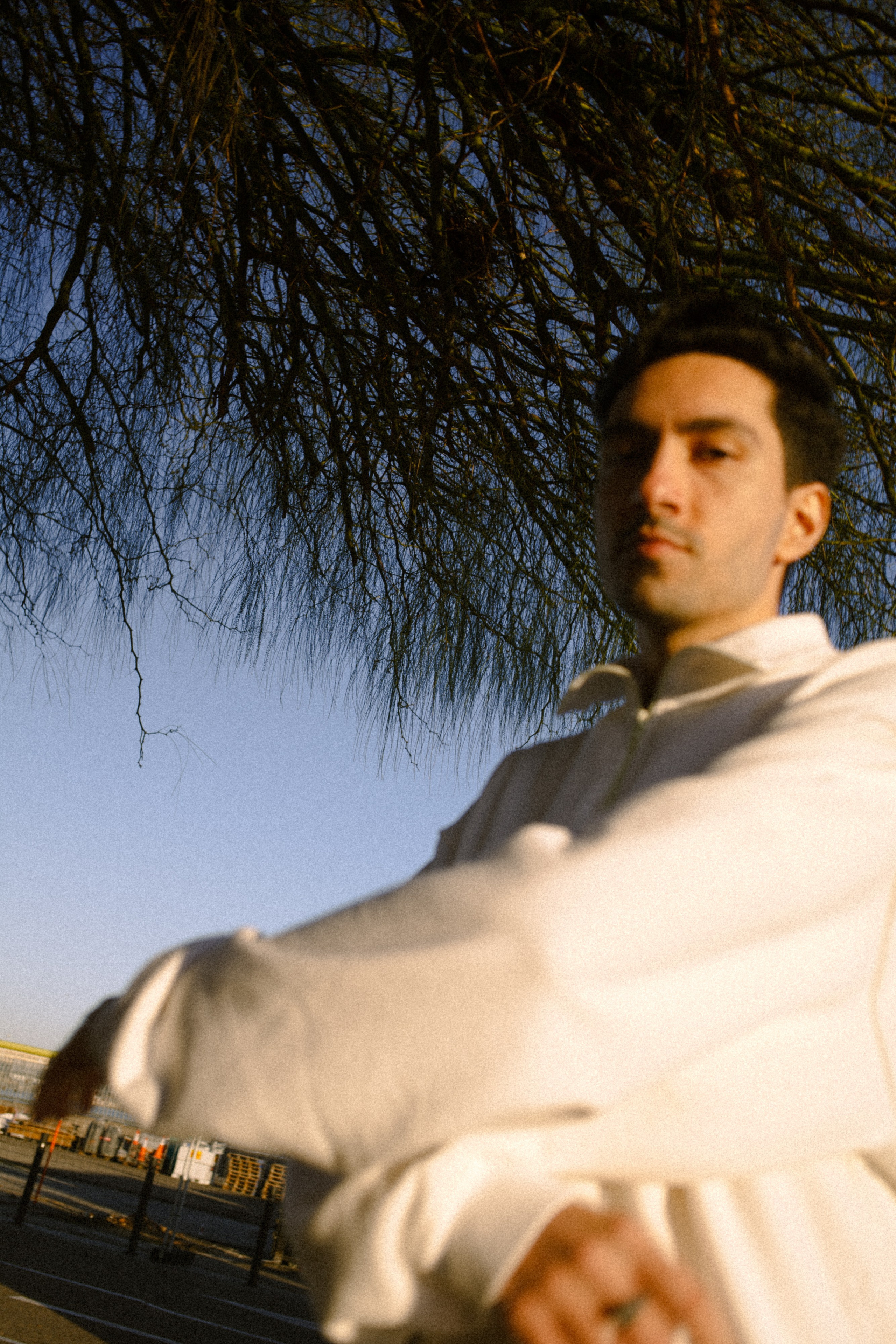candid portrait of a man outdoors with blue sky and trees, natural light photography Barcelona