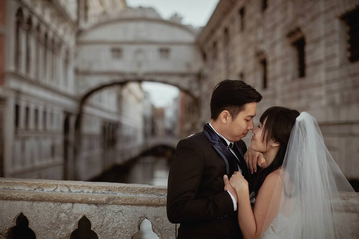 Romantic couple portrait of Daisy and Luis near the Bridge of Sighs during their honeymoon photo session.