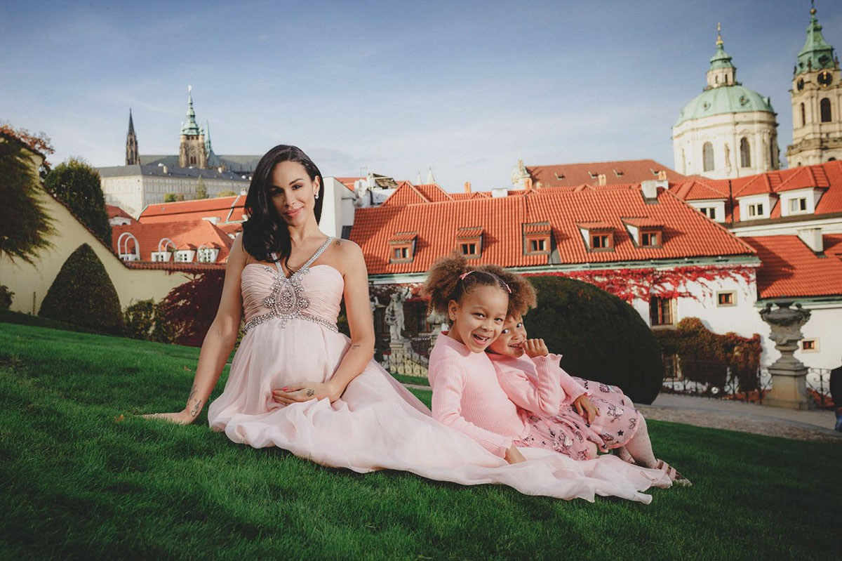 Mother and two daughters laughing together on the grass at Vrtba Garden