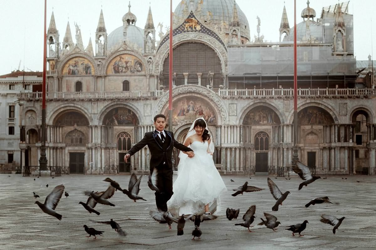 Daisy and Luis during a romantic sunrise honeymoon photography session at St. Mark’s Square in Venice with golden light