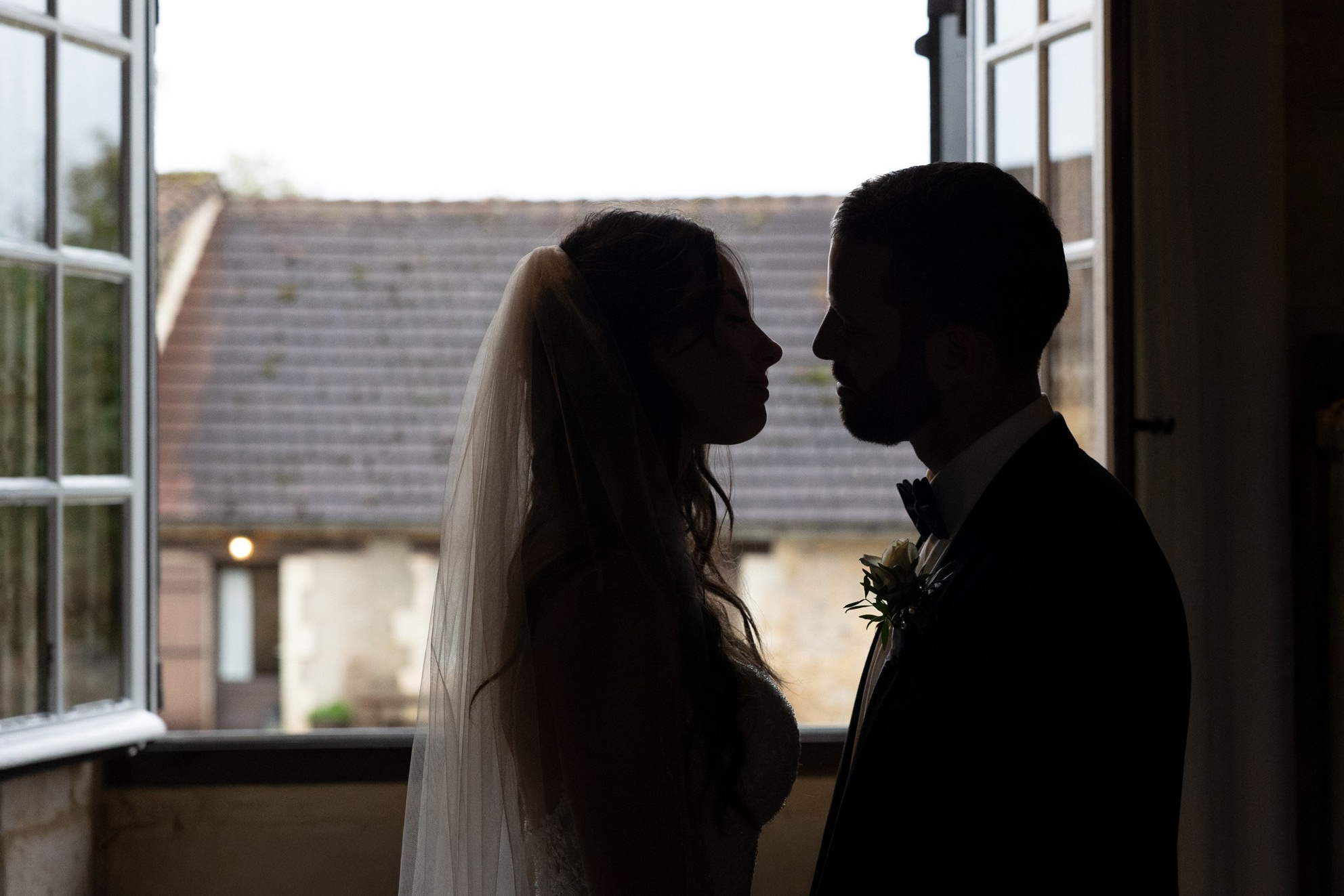 Bride and groom in soft window light during a documentary wedding moment in France.