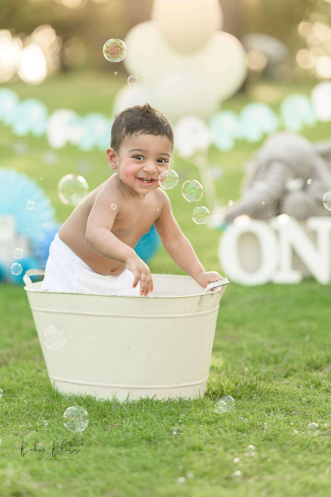 baby enjoying bubble bath in outdoor baby photoshoot in MIA park in Qatar.