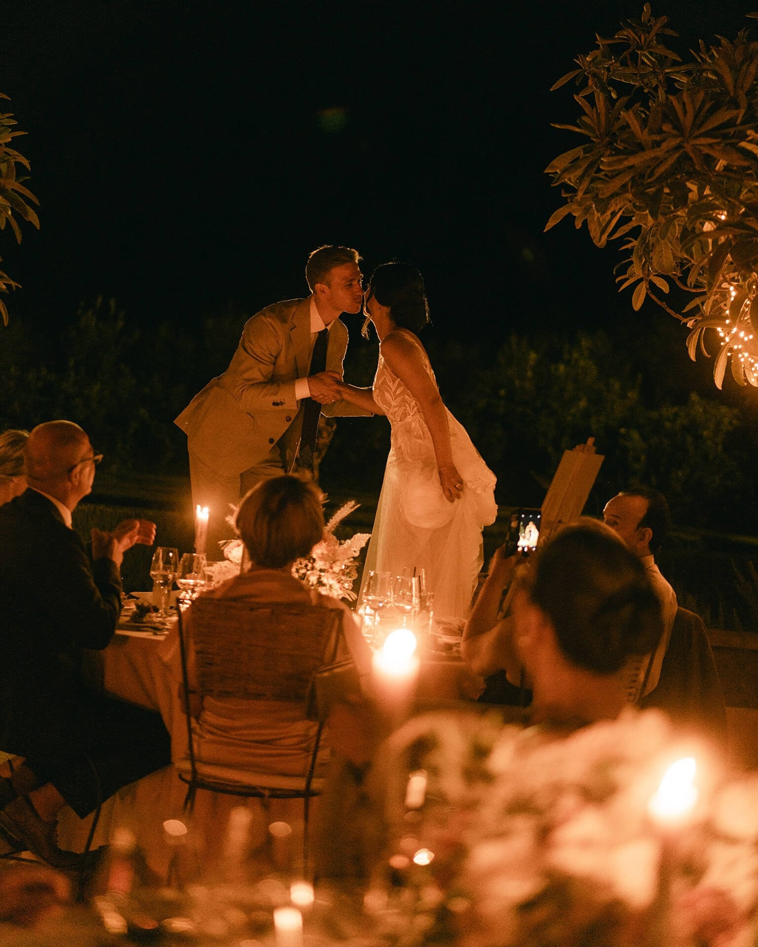 Couple kissing during candlelit reception 
