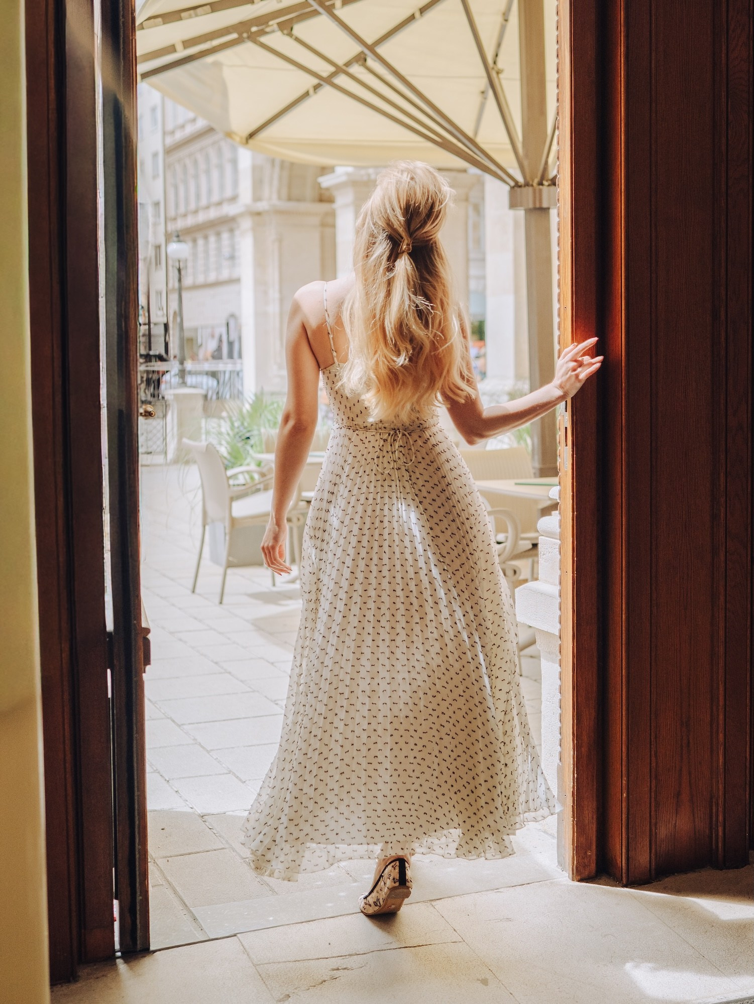 Woman leaving a Vienna café during a cinematic solo photoshoot