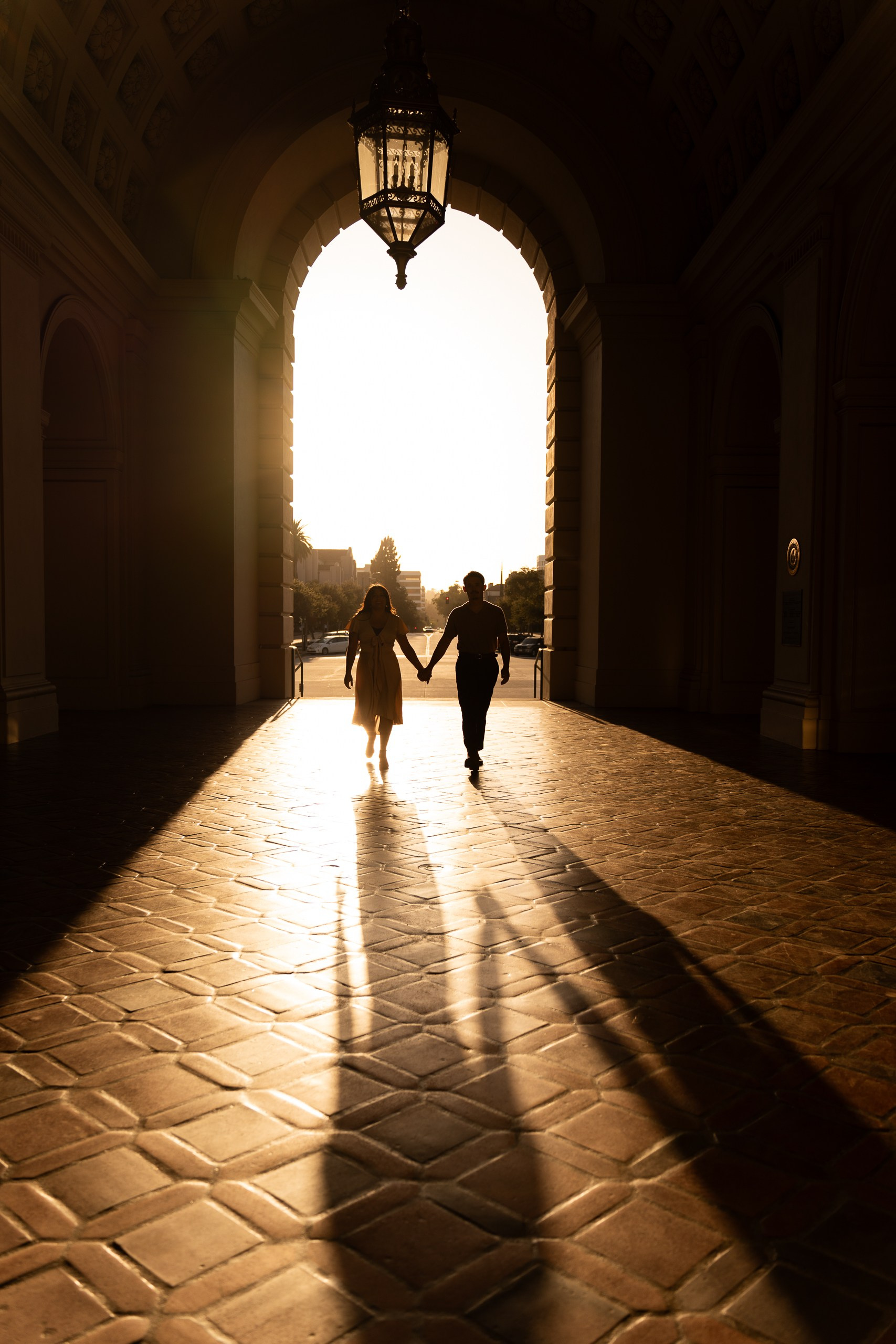 Artistic engagement photo session captured in Pasadena City Hall during golden hour