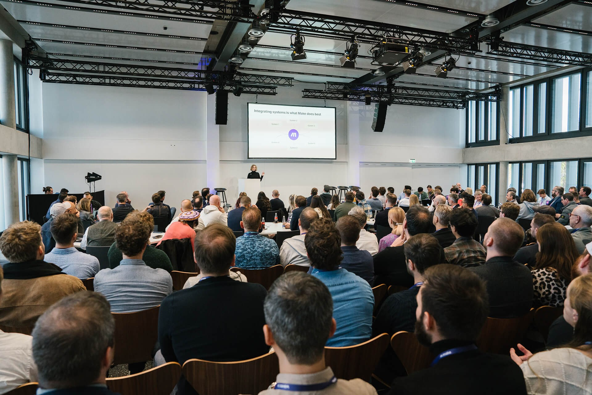 Large audience seated in a modern conference hall during a keynote speech