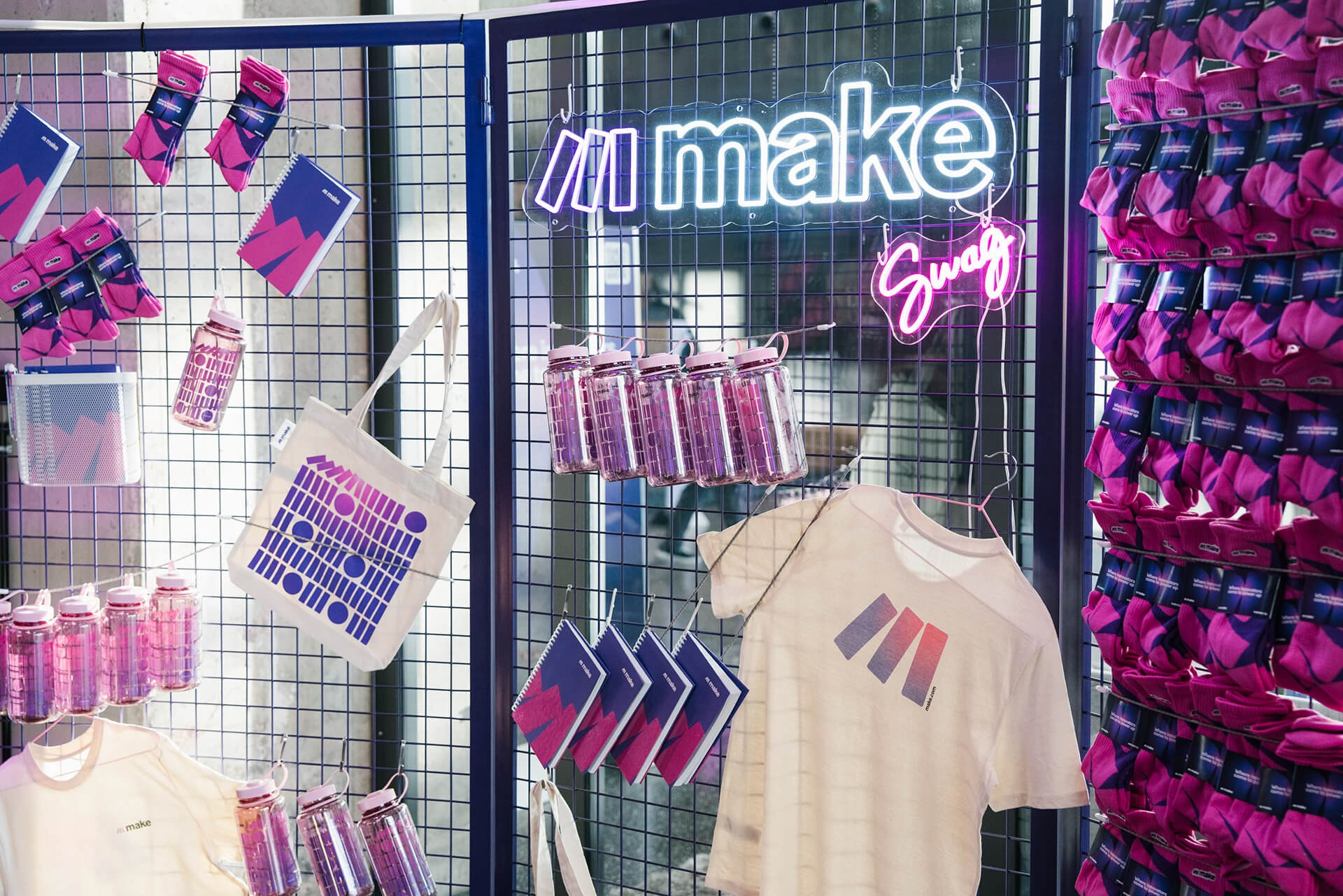 Merchandising-Display mit gebrandeten T-Shirts und Geschenken bei einem Make.com-Firmenevent