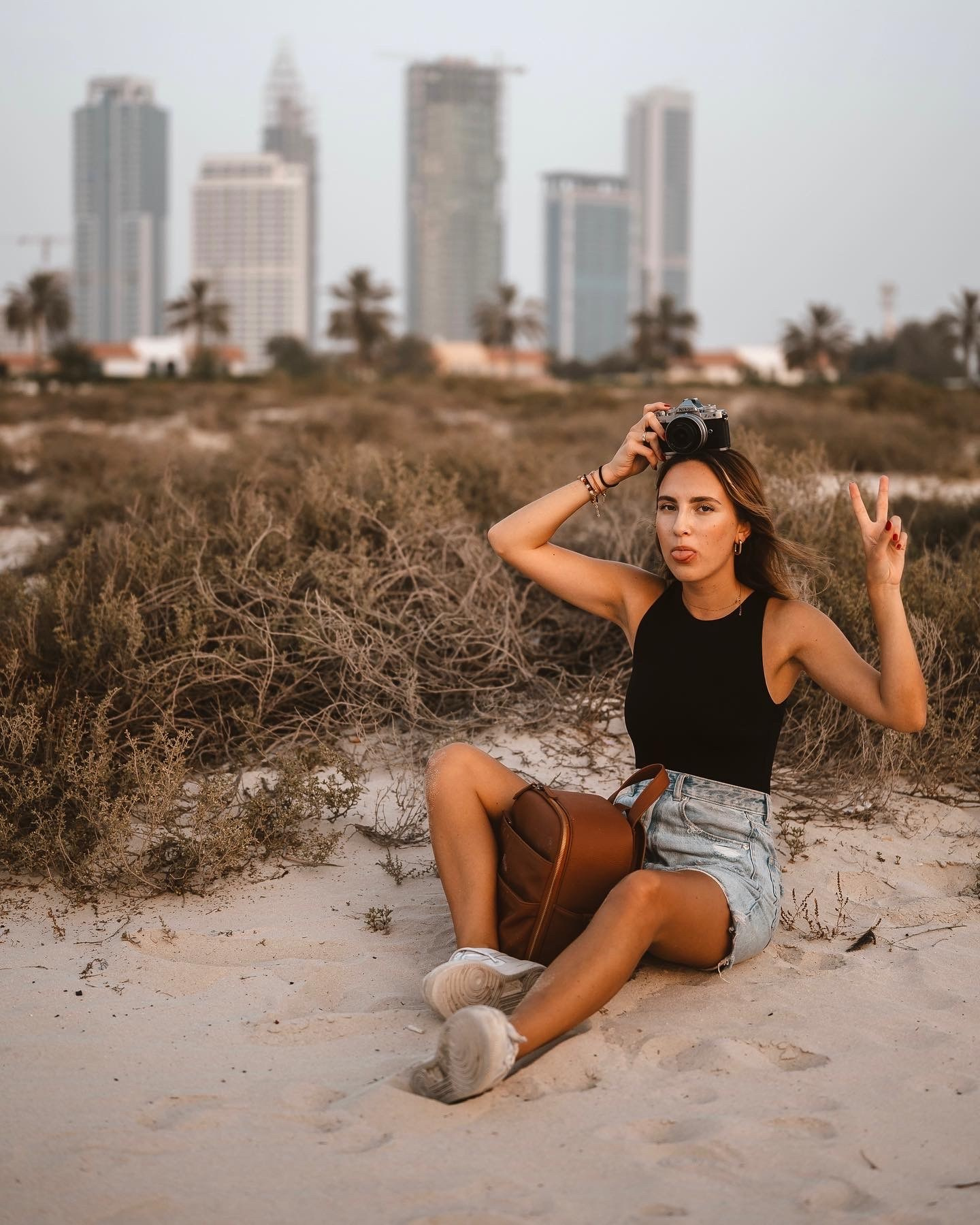 Sesja kobieca na pustyni z panoramą miasta – fotografia kobieca w plenerze, Poznań.