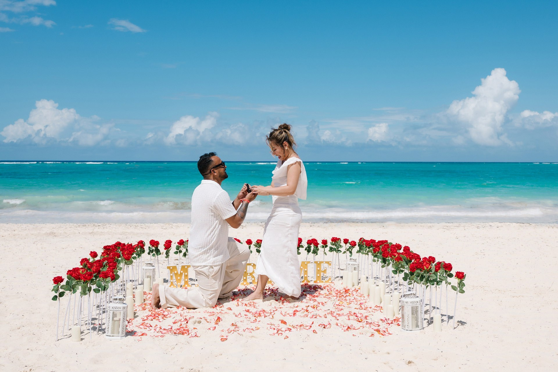 Classic romantic beach engagement in Punta Cana with rose path and proposal setup