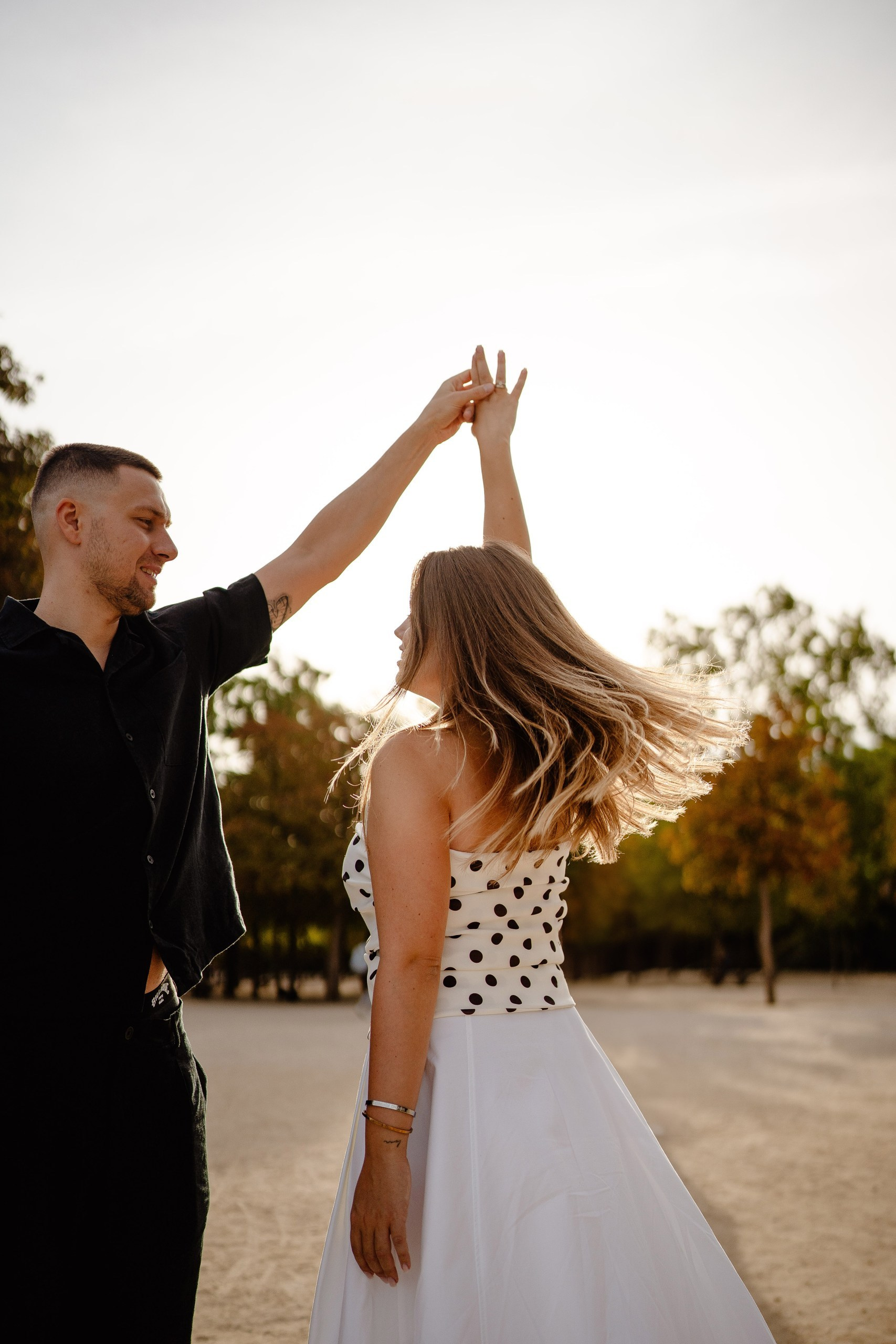 Couple dancing in Retiro park during the sunset.