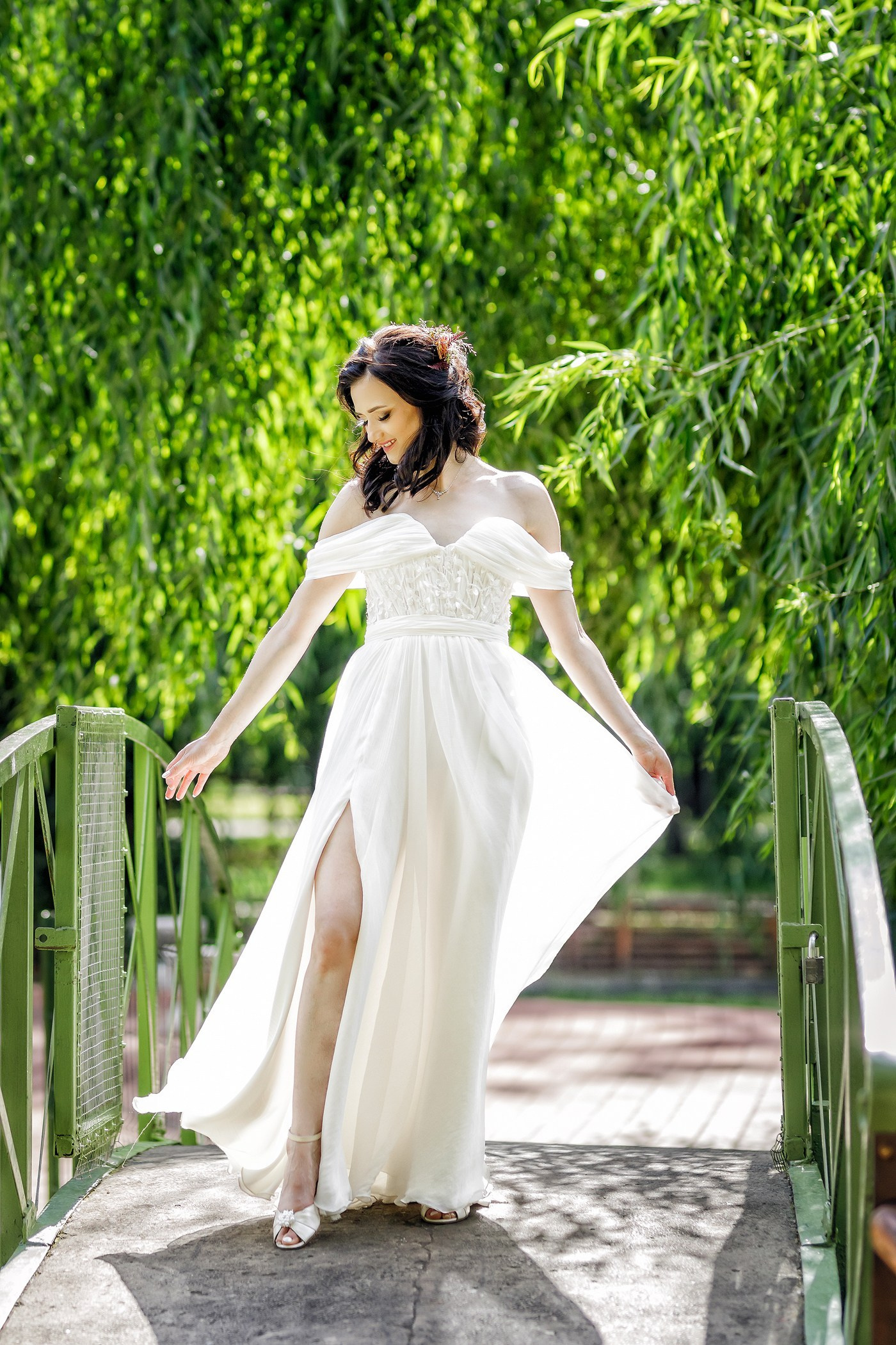 Portret mireasă în rochie albă pe pod de lemn în natură - fotografie de nuntă creativă