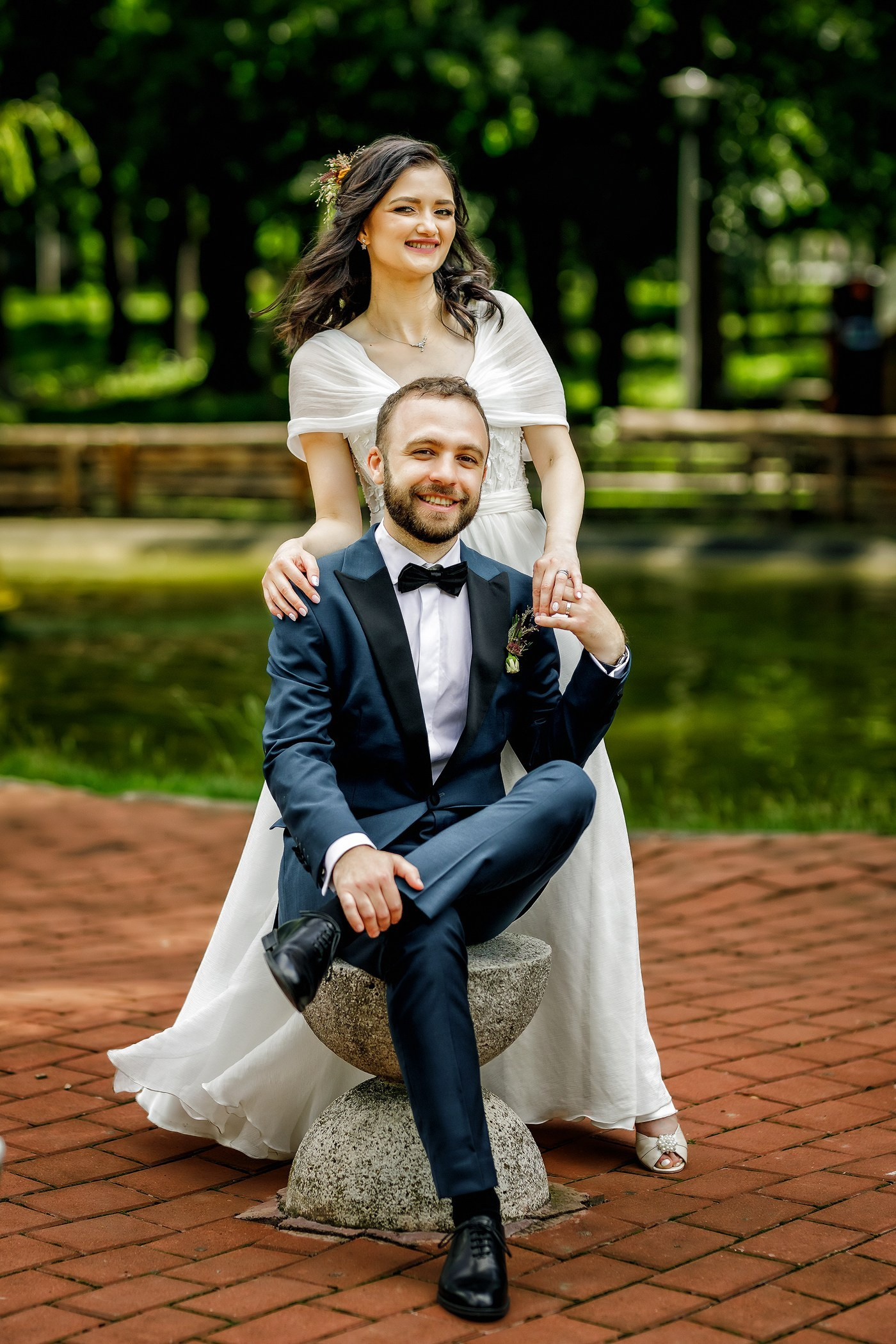 Mire și mireasă stând pe iarbă în parc - ședință foto nuntă realizată de echipa Foto Lens
