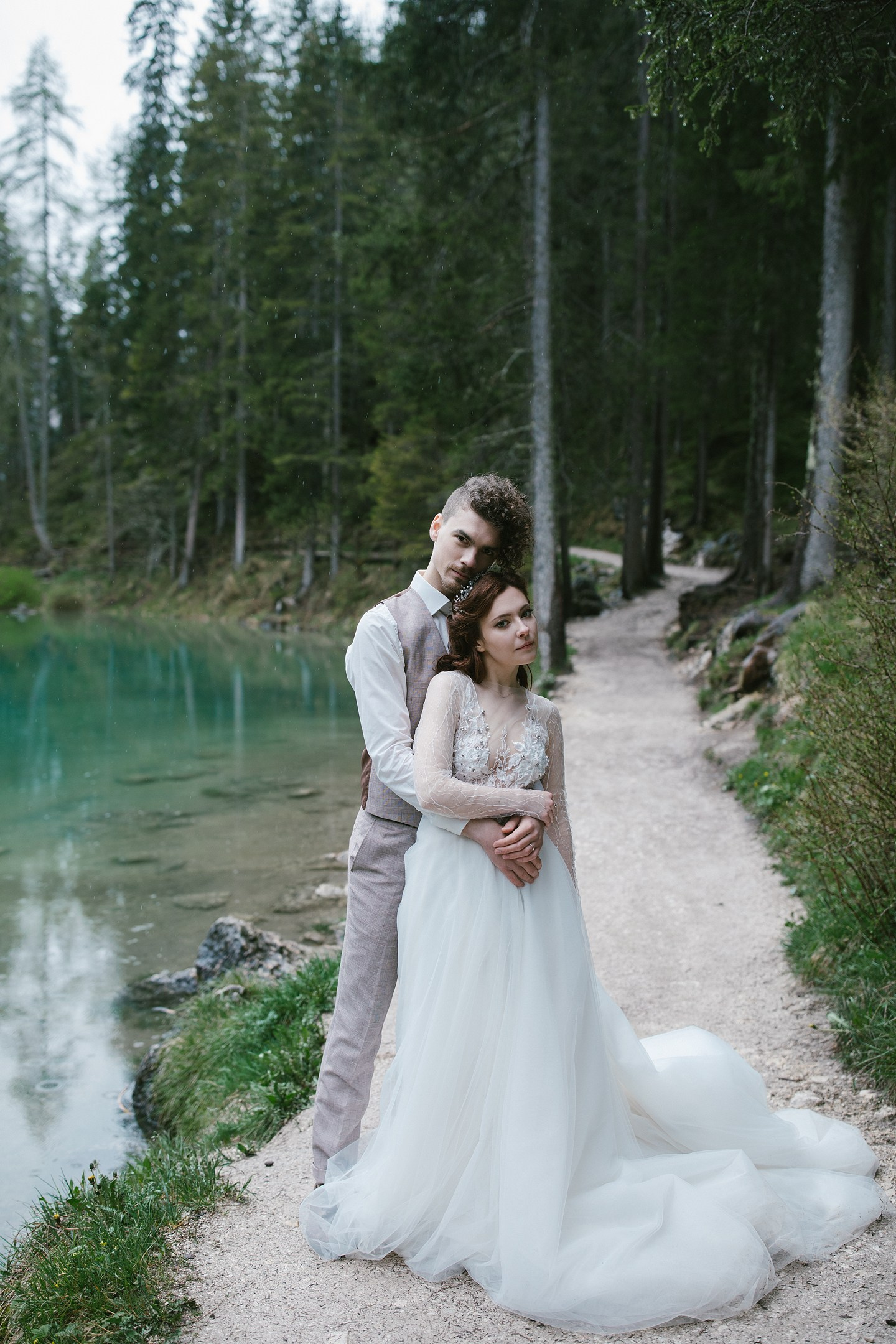 Couple embracing by the lake in light rain