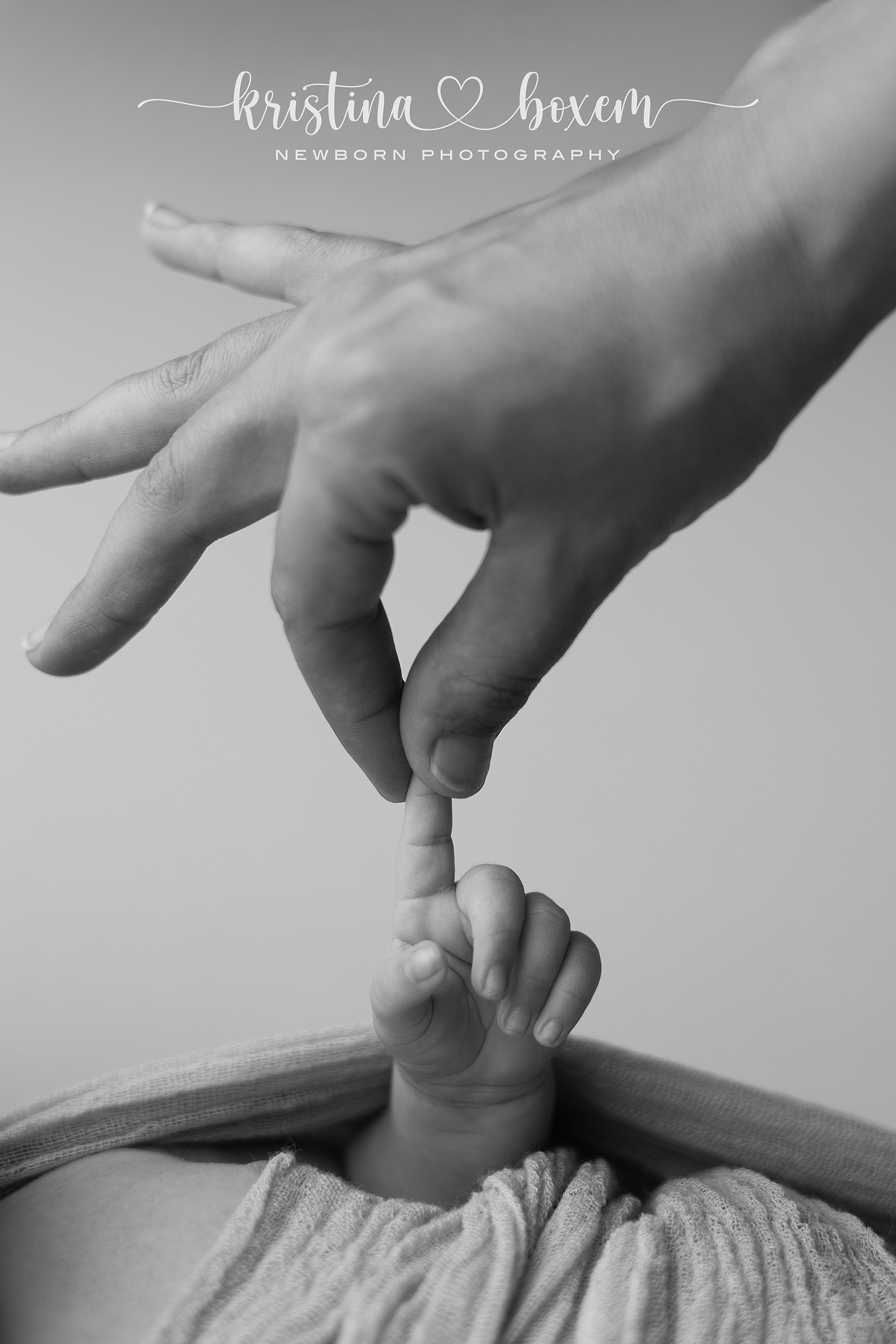 Kleine babyvoetjes die voorzichtig worden vastgehouden door papa tijdens een liefdevolle newborn fotosessie in de regio Breda, vastgelegd in een veilige en ontspannen sfeer.