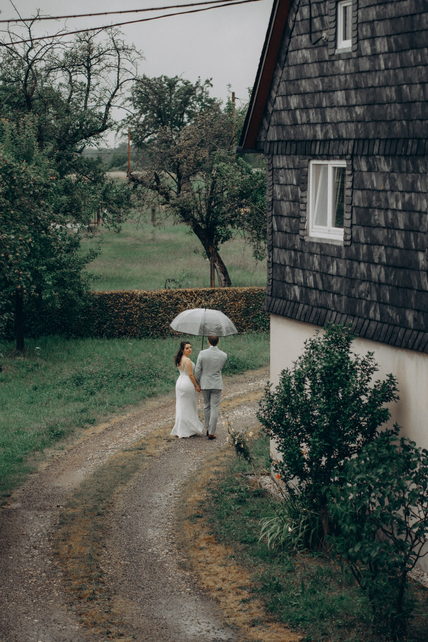 Braut und Bräutigam spazieren im Regen – natürliche Hochzeitsfotos Dresden