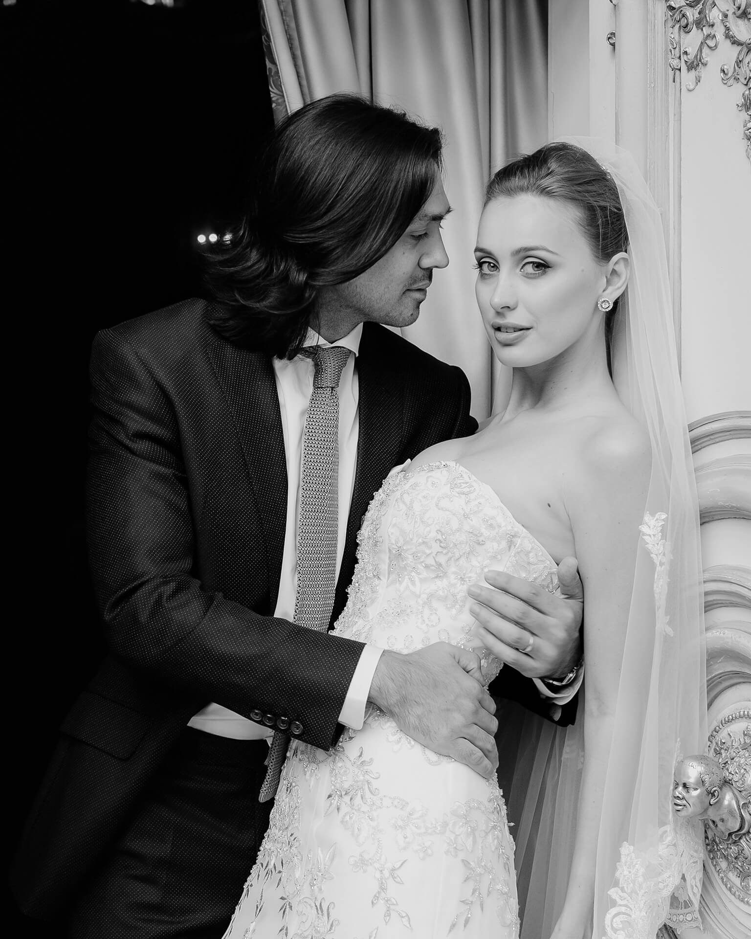 Bride and groom embracing indoors fine art