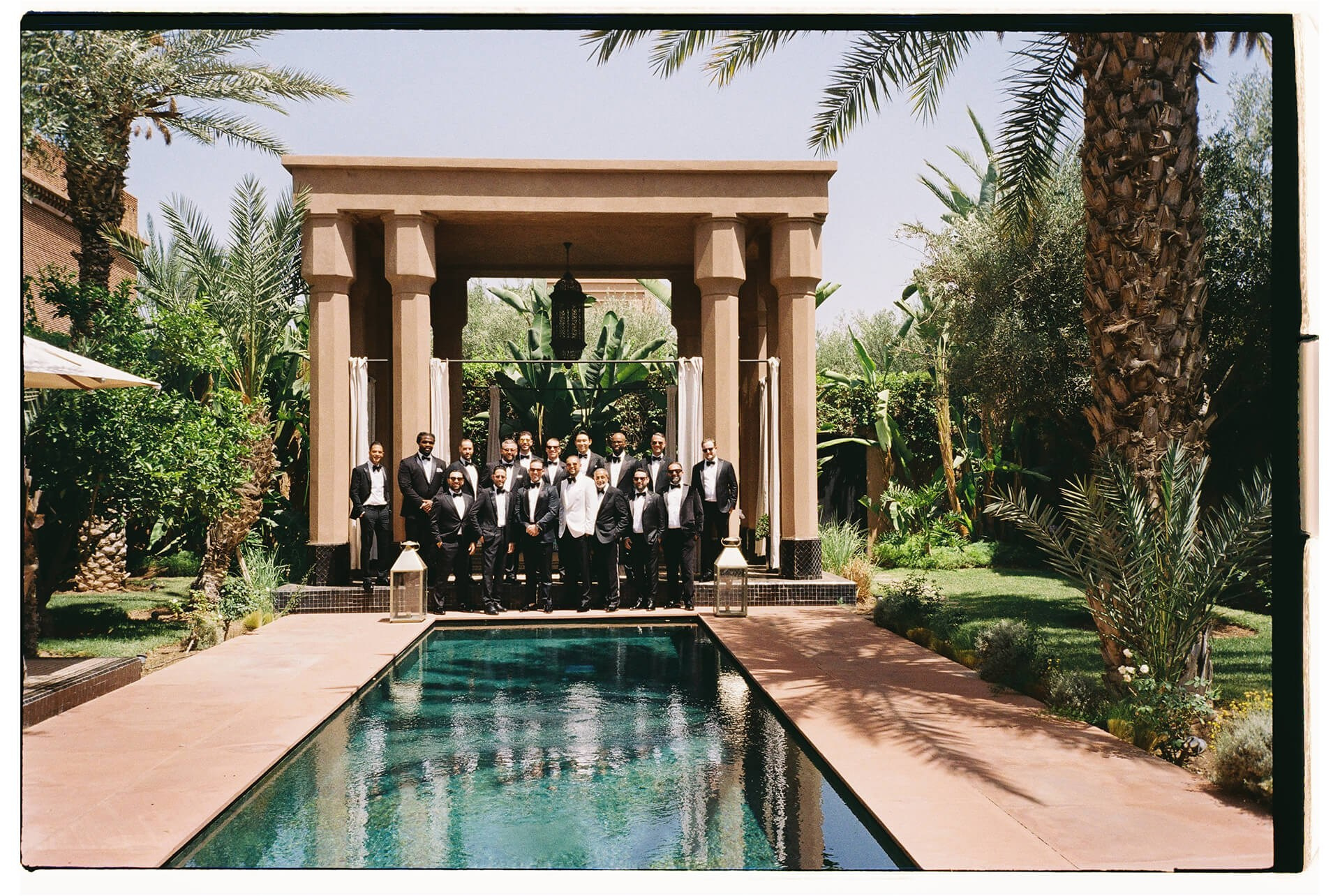 Groomsmen by reflecting pool during Morocco destination wedding portraits