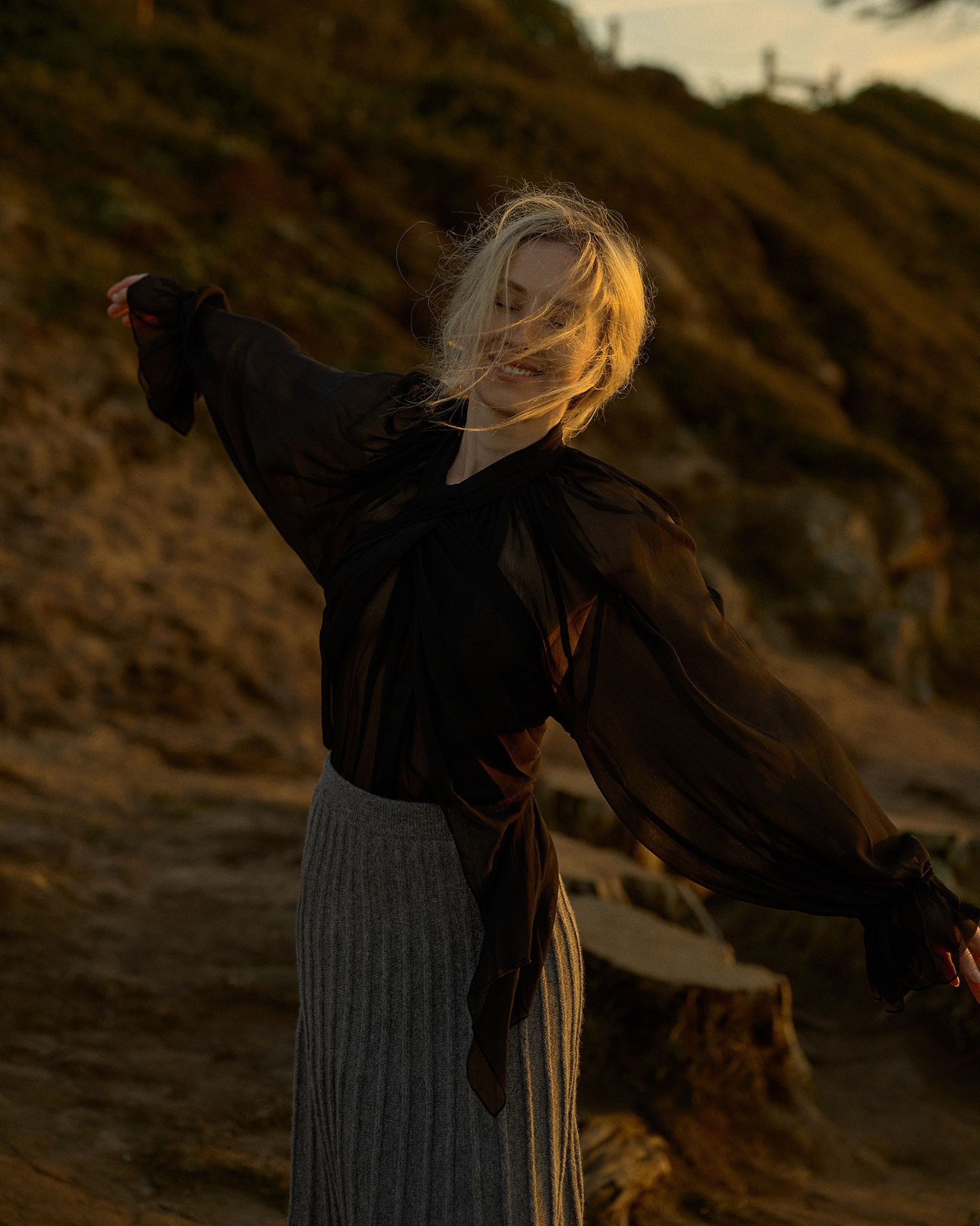 Emotional female portrait with sunset backdrop, stylish beach photoshoot in San Francisco for model portfolio.