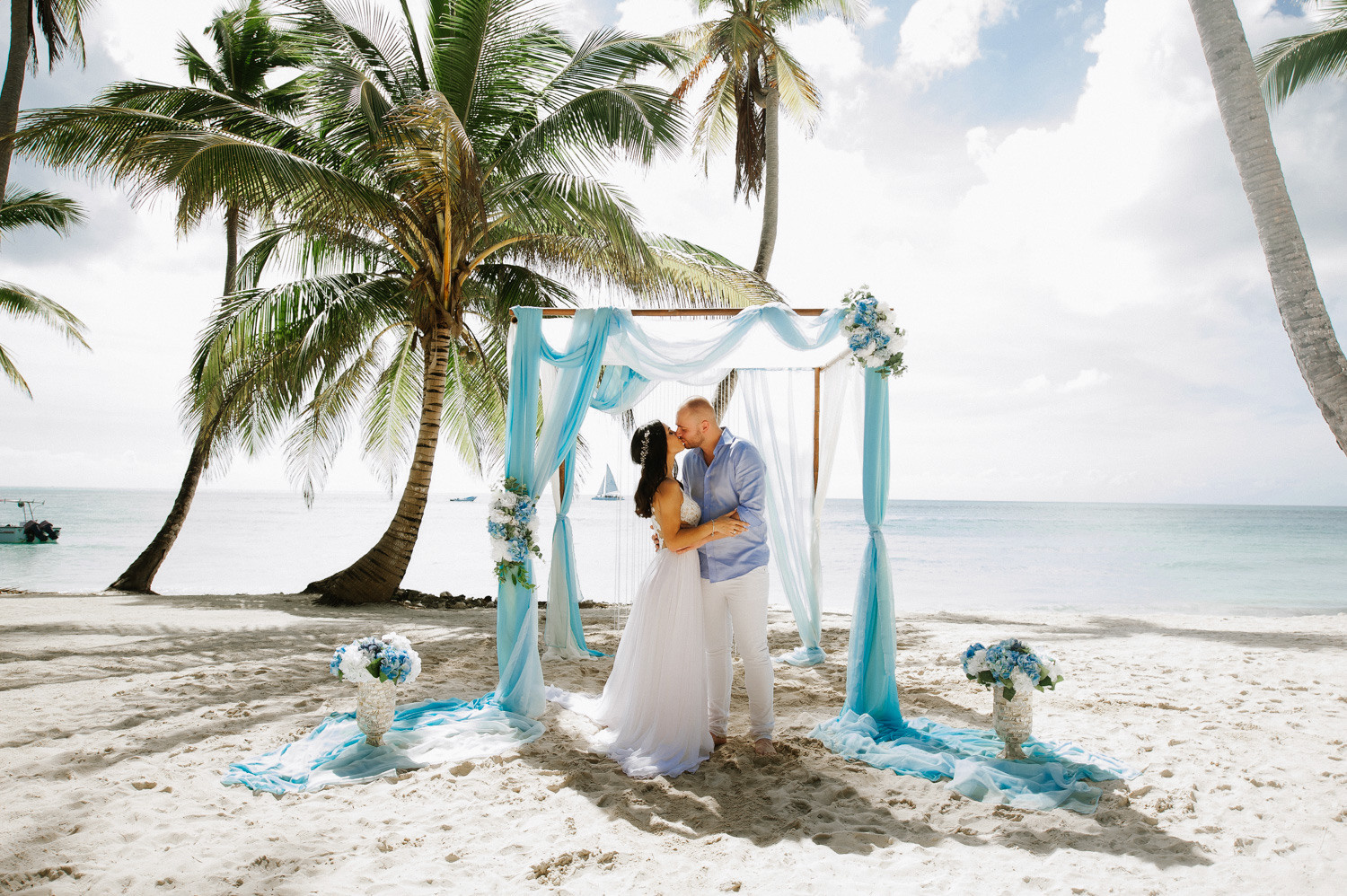 Жених и невеста целуют друг друга во время свадебной церемонии. 