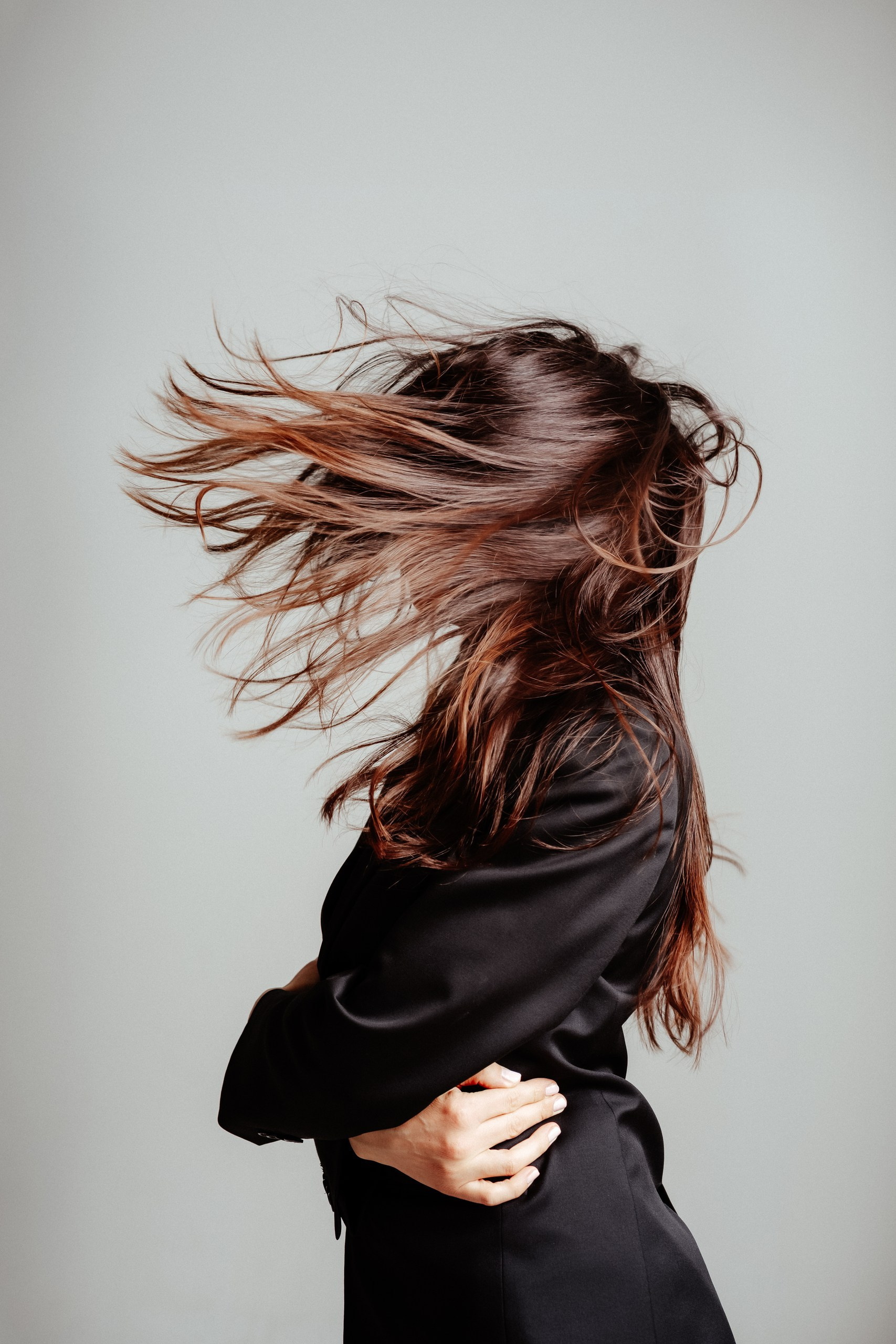 profil mlade žene sa kosom preko lica koju duva vetar 