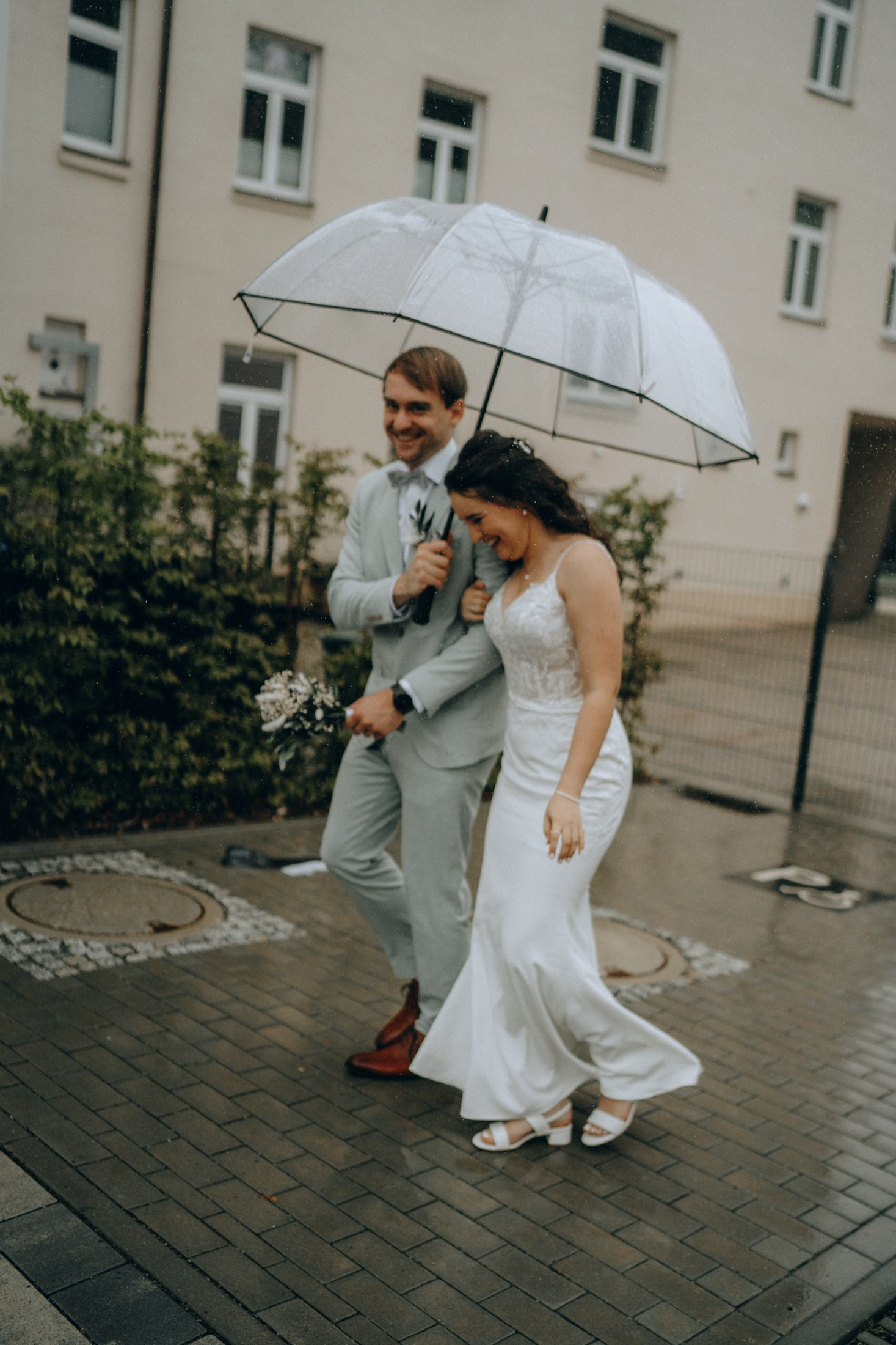 Brautpaar läuft im Regen mit Schirm – stimmungsvolle Hochzeitsfotos Sachsen