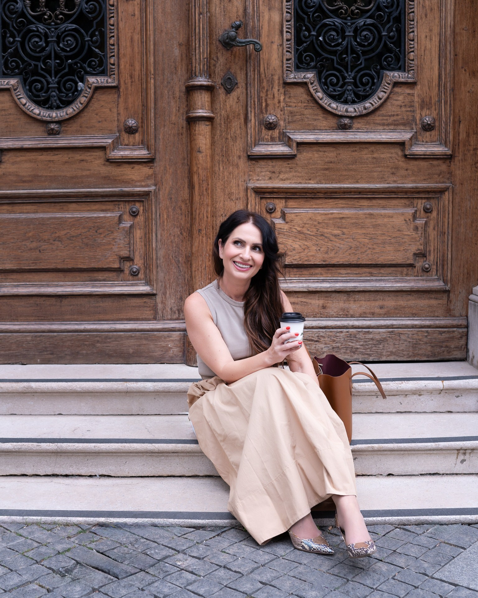 žena sedi na stepeništu i smeje se 