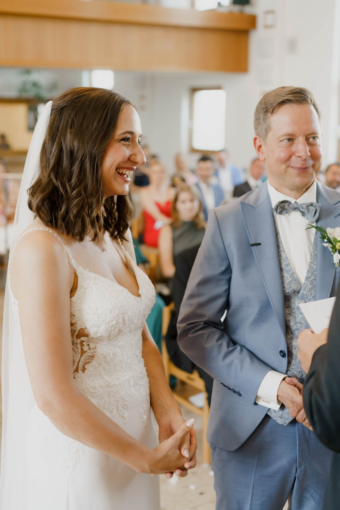 Bride and groom exchanging vows face to face, both smiling and holding hands during the Stuttgart wedding ceremony