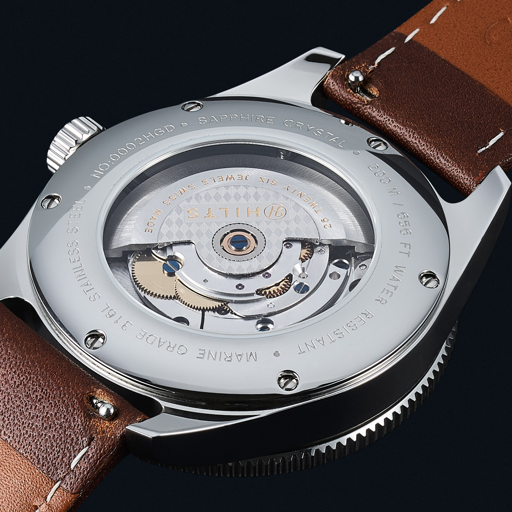 Automatic movement seen through the caseback of a watch on a leather strap